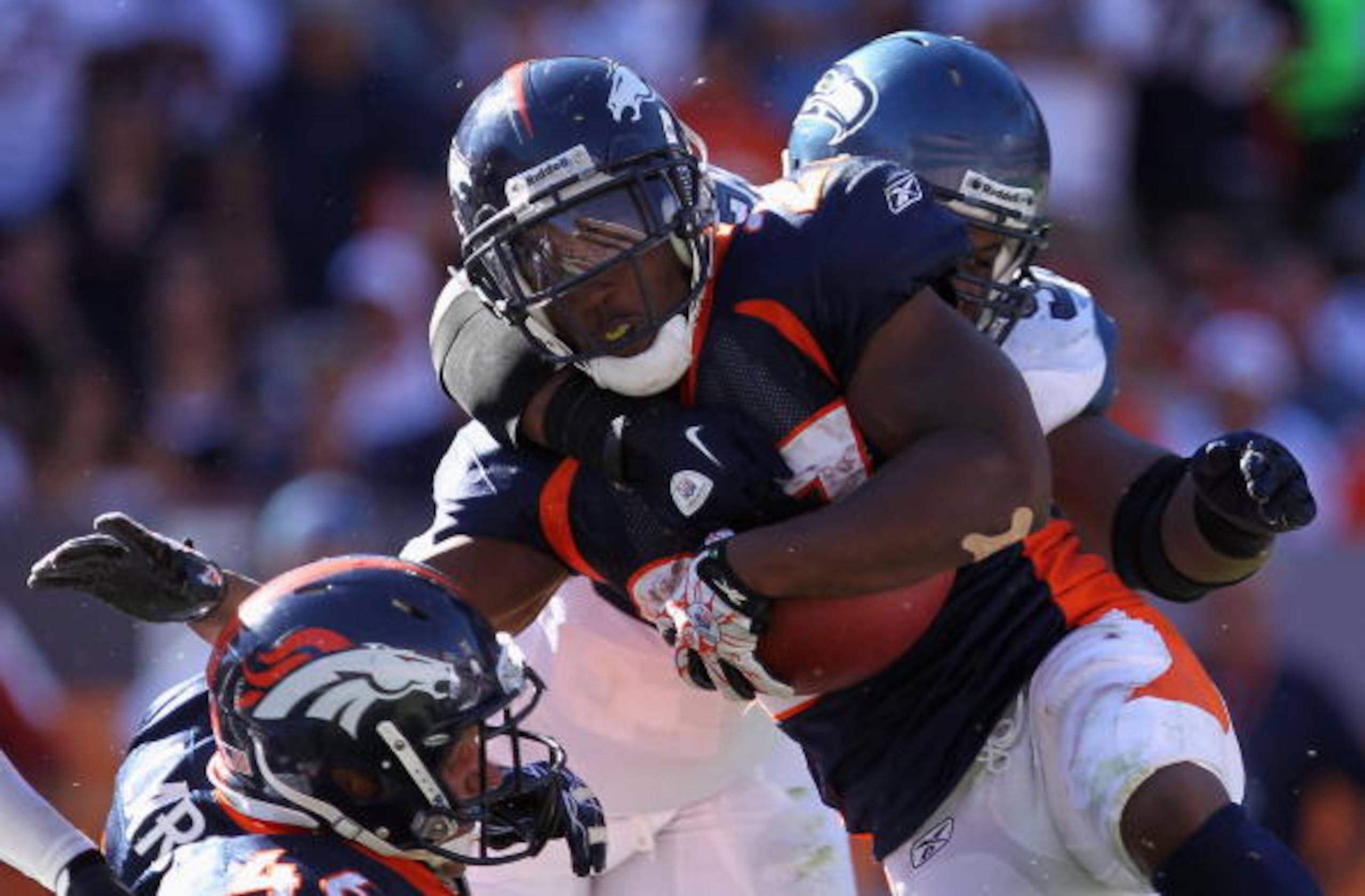 DENVER - SEPTEMBER 19:  Running back Knowshon Moreno #27 of the Denver Broncos is stopped by defensive tackle Brandon Mebane #92 of the Seattle Seahawks at INVESCO Field at Mile High on September 19, 2010 in Denver, Colorado. The Broncos defeated the Seah