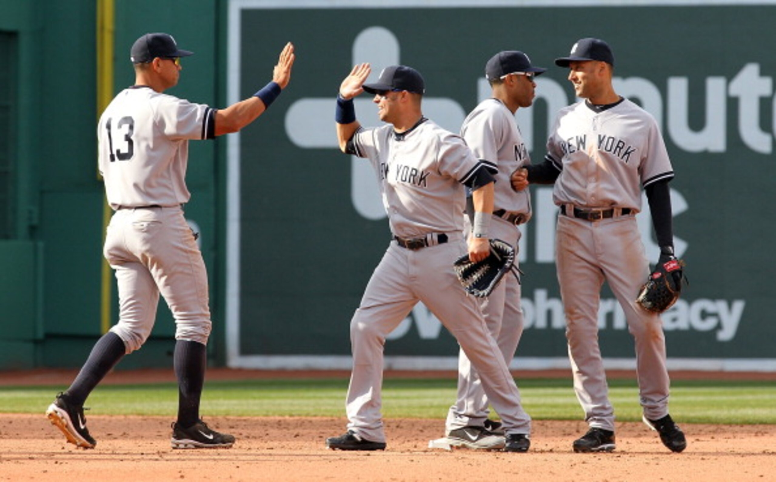 BOSTON, MA - APRIL 9:  Derek Jeter #2 of the New York Yankees celebrates with teammates Robinson Cano #24, Alex Rodriguez #13 and Nick Swisher #33 after defeating the Red Sox 9-4 at Fenway Park April 9, 2011 in Boston, Massachusetts. (Photo by Jim Rogash/