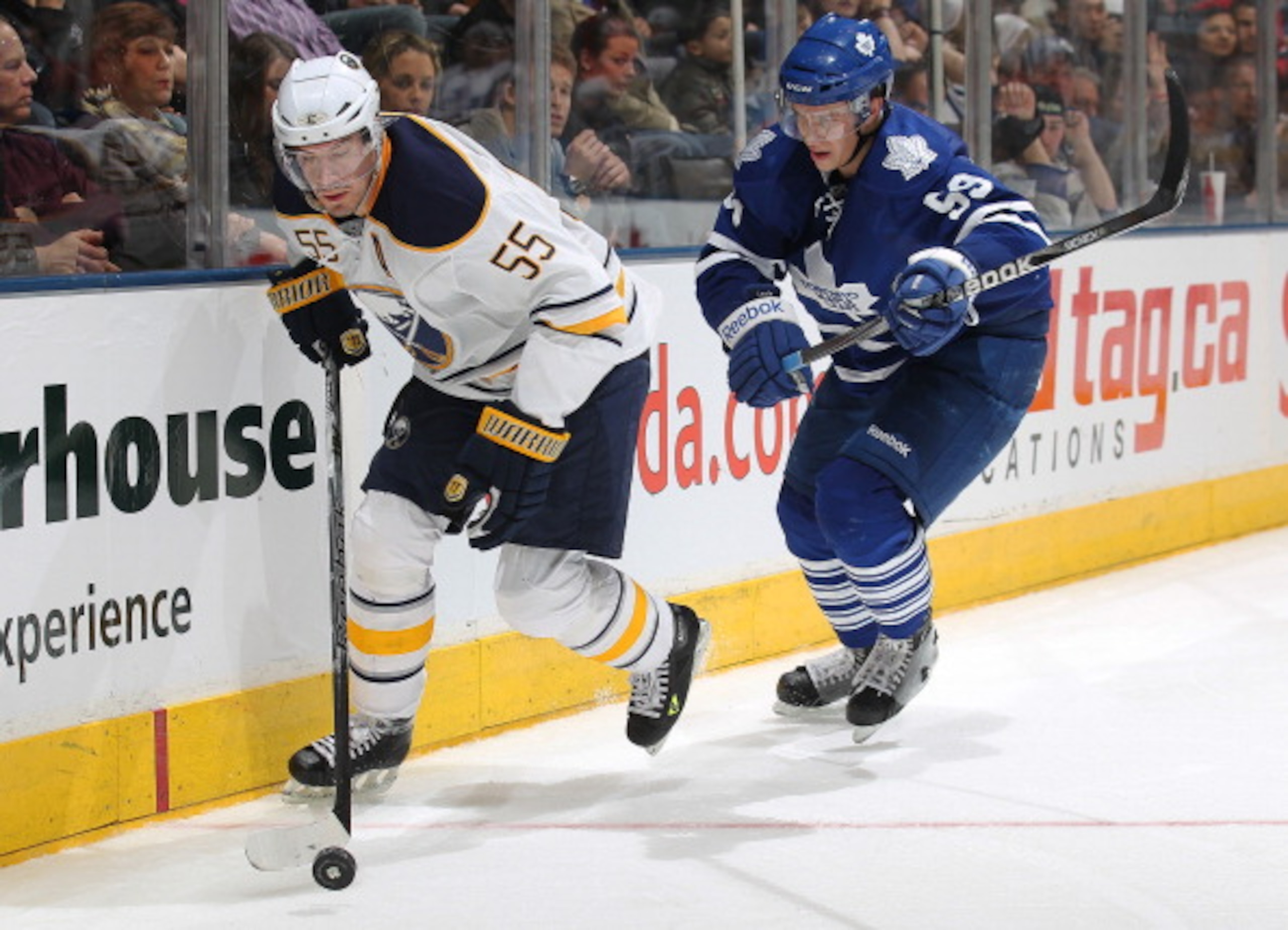 TORONTO, CANADA - MARCH 12:  Jochen Hecht #55 of the Buffalo Sabres controls the puck in front of Keith Aulie #59 of the Toronto Maple Leafs in a game on March 12, 2011 at the Air Canada Centre in Toronto, Canada. The Leafs defeated the Sabres 4-3. (Photo