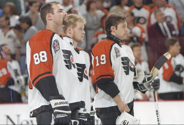 31 May 1997:  Philadelphia Flyers center Eric Lindros (left) and rightwinger Mikael Renberg (right) flank an unidentified teammate during Game 1 of the Stanley Cup Finals against the Detroit Red Wings at the CoreStates Center in Philadelphia, Pennsylvania