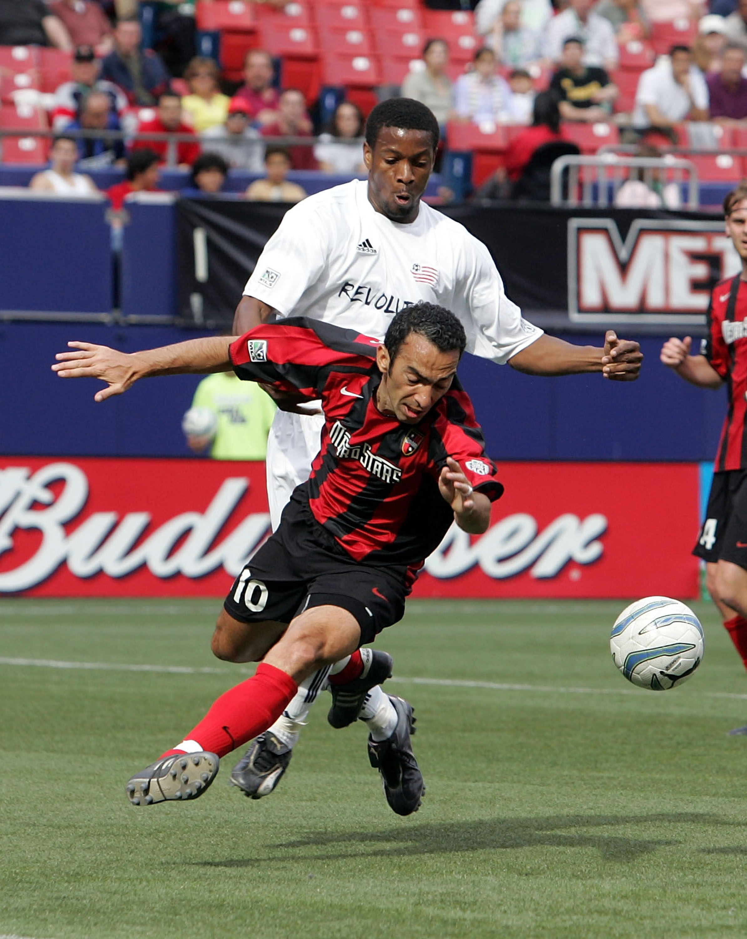 EAST RUTHERFORD, NJ - MAY 21:  Youri Djorkaeff #10 of the Metro Stars is defended by Avery John #4 of the New England Revolution as he tries to play the ball during their Major League Soccer match on May 21, 2005 at Giants Stadium in East Rutherford, New