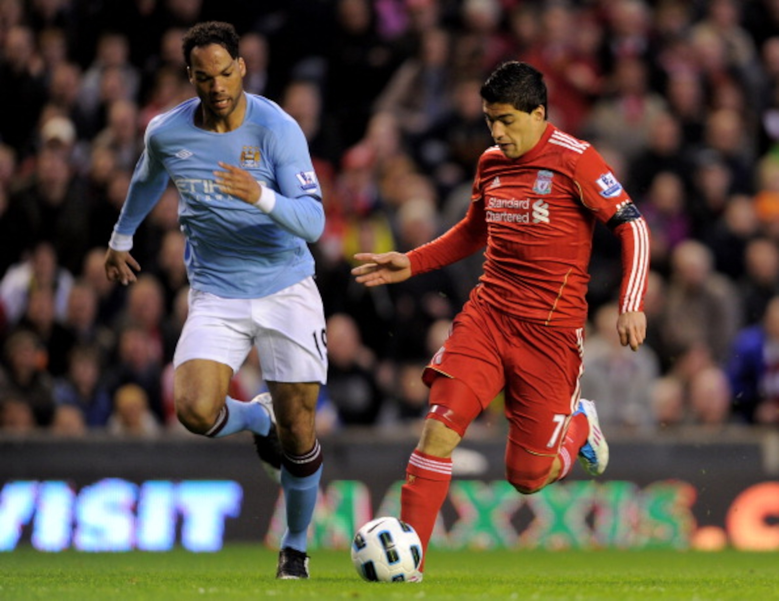 LIVERPOOL, ENGLAND - APRIL 11:  Luis Suarez of Liverpool is pursued by Joleon Lescott of Manchester City during the Barclays Premier League match between Liverpool and Manchester City at Anfield on April 11, 2011 in Liverpool, England. (Photo by Michael R