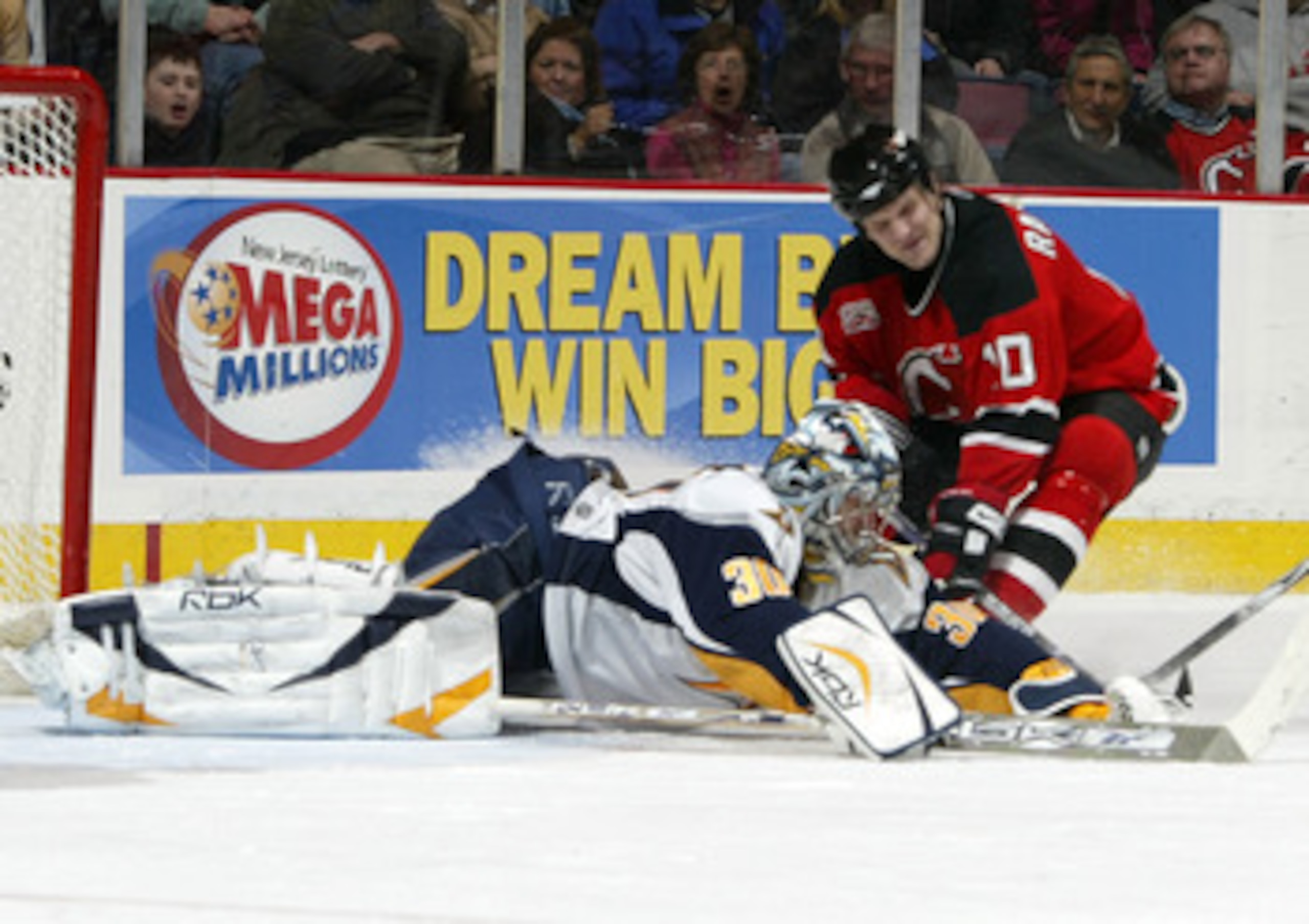 EAST RUTHERFORD, NJ - FEBRUARY 03: Ryan Miller #30 of the Buffalo Sabres makes a diving save as Erik Rasmussen #10 goes for a rebound during their game at the Continental Airlines Arena on February 3, 2007 in East Rutherford, New Jersey.  (Photo by Andy M