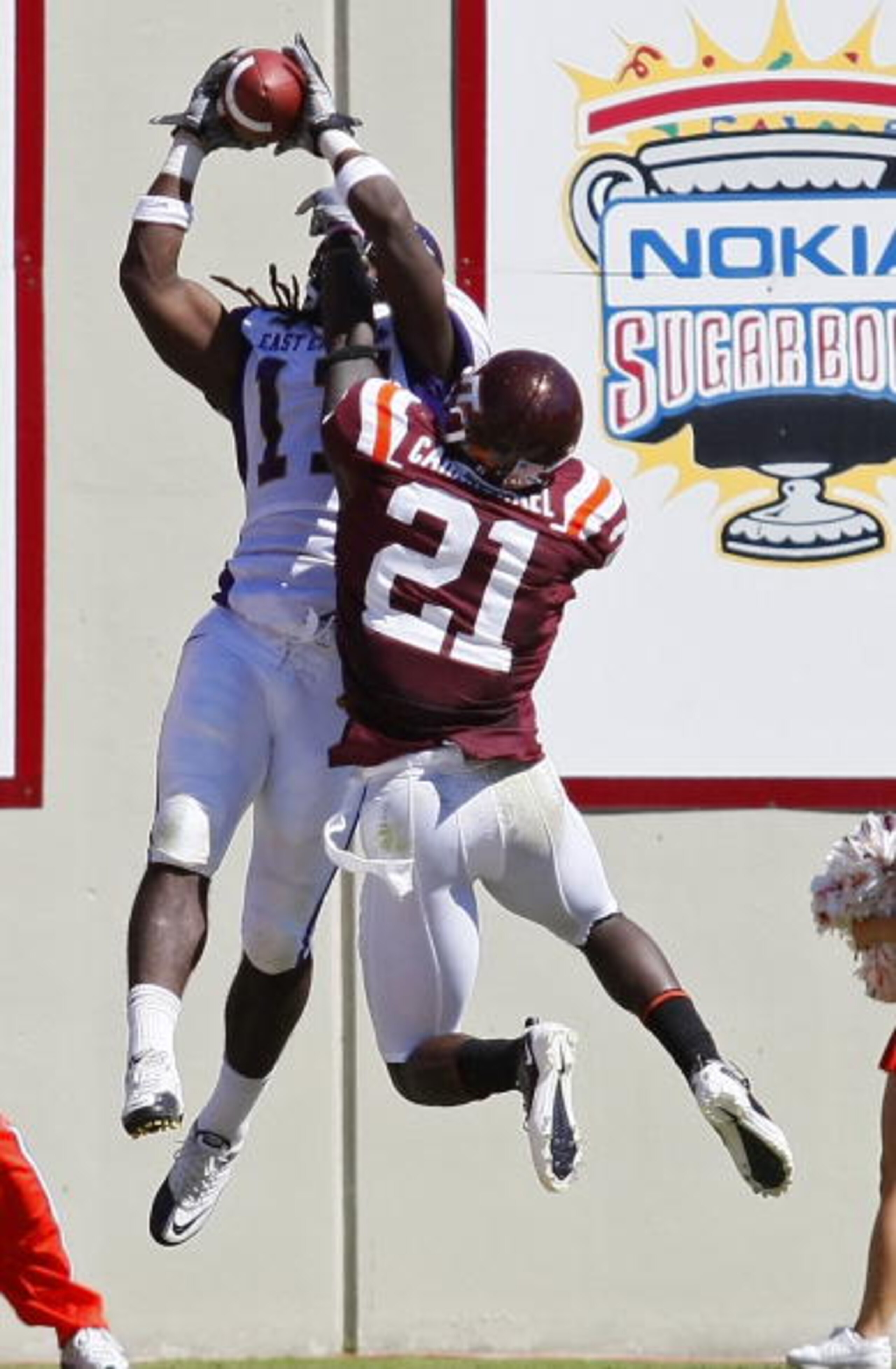 BLACKSBURG, VA - SEPTEMBER 18:  Wide receiver Dwayne Harris #17 of the East Carolina Pirates catches a touchdown pass as cornerback Rashad Carmichael #21 of the Virginia Tech Hokies defends at Lane Stadium on September 18, 2010 in Blacksburg, Virginia.  (