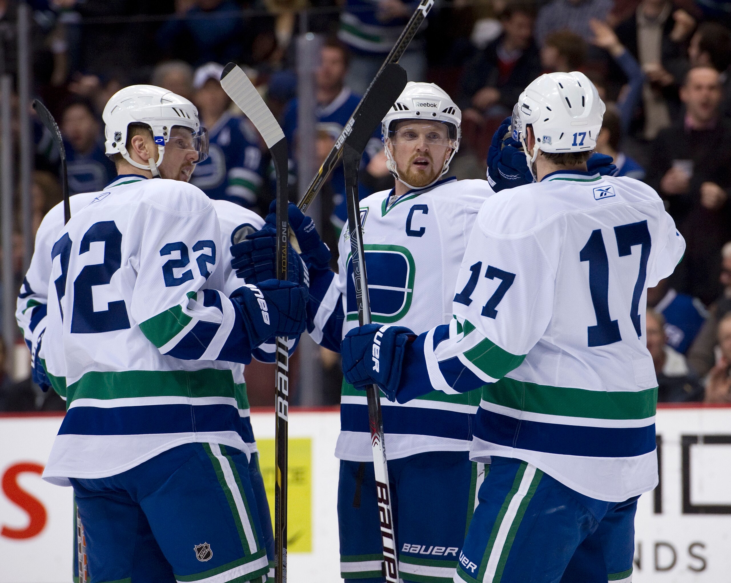 VANCOUVER, CANADA - FEBRUARY 22: Henrik Sedin #33 celebrates with Daniel Sedin #22 and Ryan Kesler #17 of the Vancouver Canucks after scoring a power play goal against the Montreal Canadiens during the second period in NHL action on February 22, 2011 at R