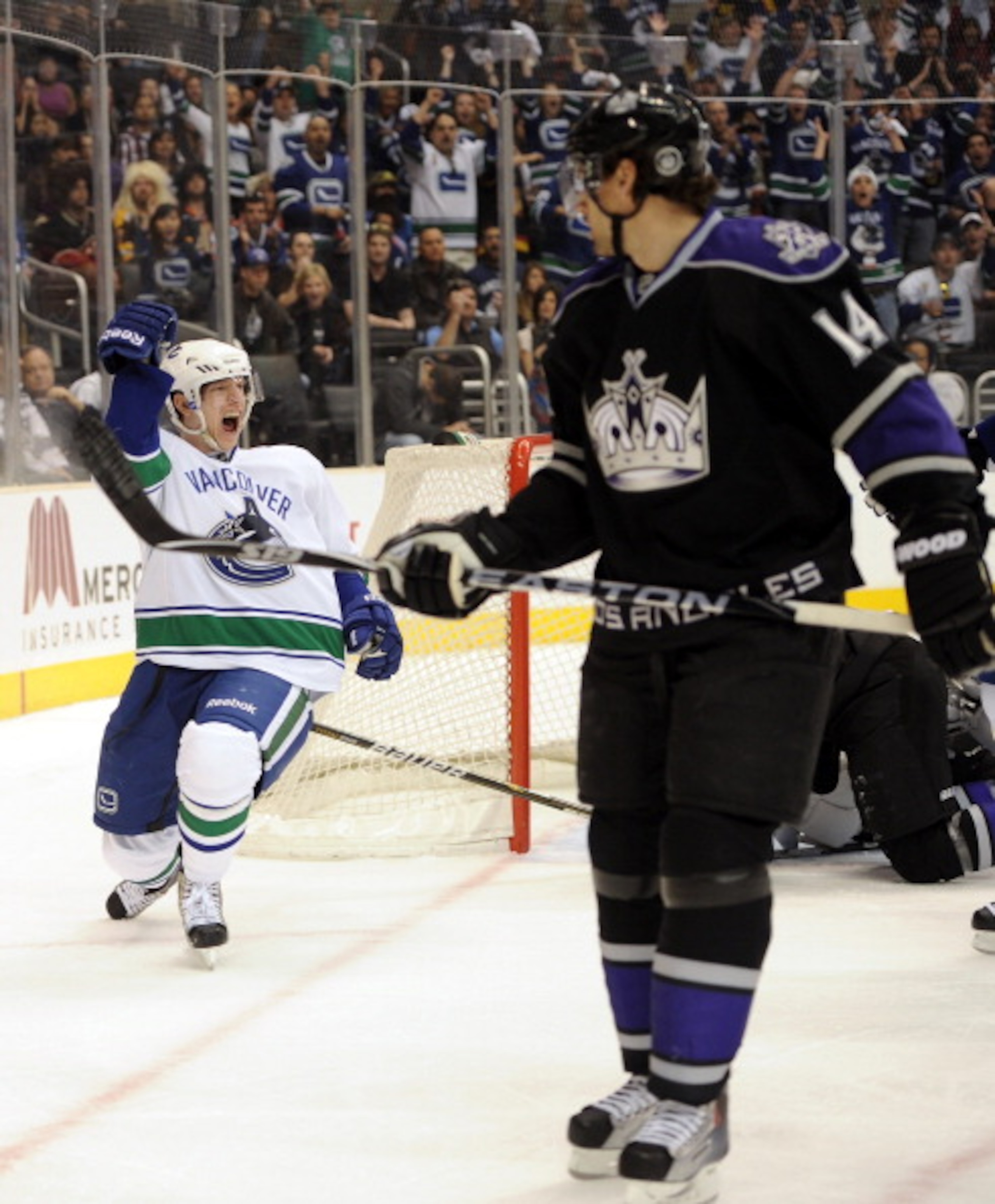 LOS ANGELES, CA - MARCH 05:  Jannik Hansen #36 of the Vancouver Canucks celebrates his goal in front of Justin Williams #14 of the Los Angeles Kings for a 1-1 tie during the first period at the Staples Center on March 5, 2011 in Los Angeles, California.