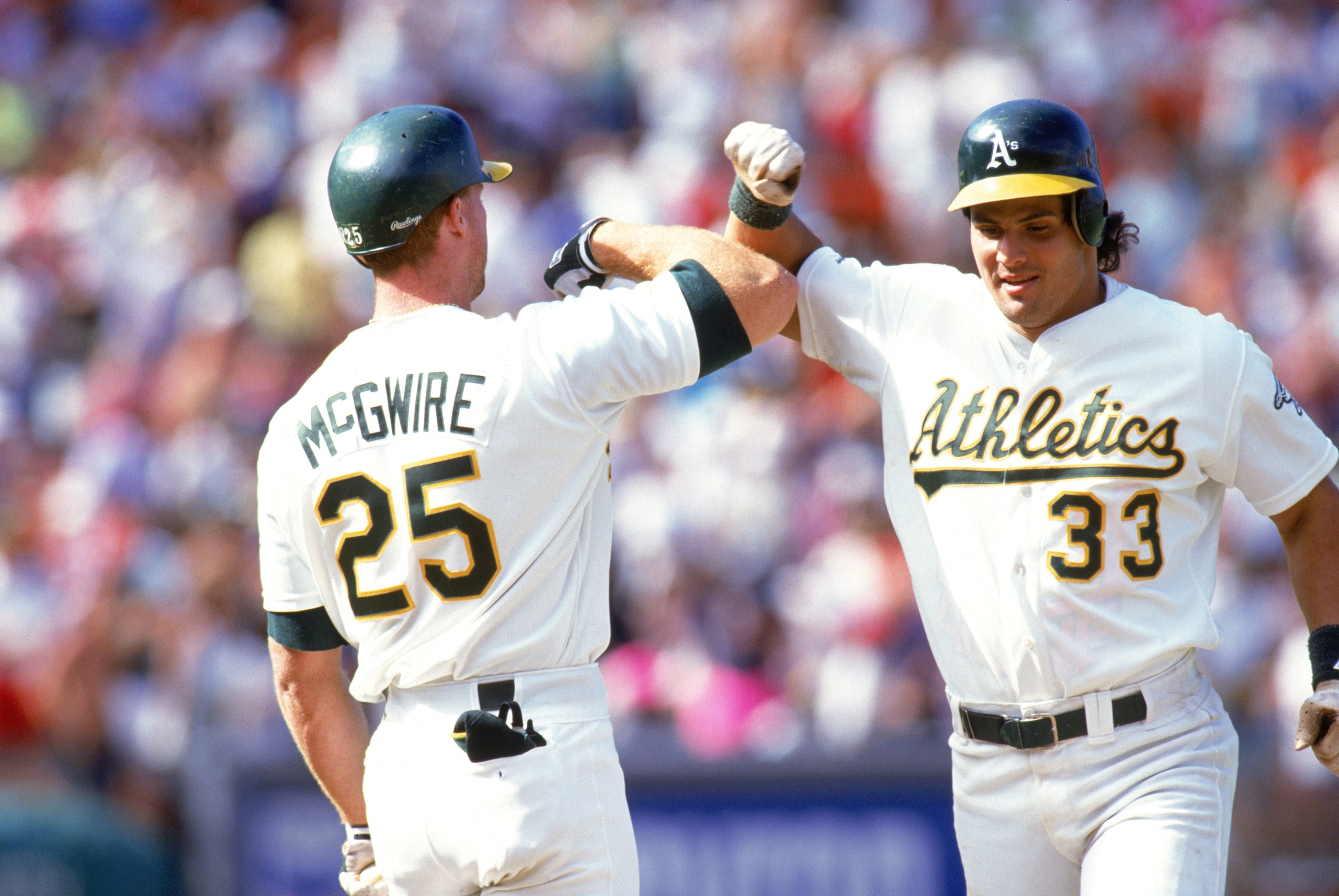 OAKLAND, CA - 1990: Jose Canseco #33 and Mark McGwire #25 of the Oakland Athletics celebrate during a 1990 MLB season game at Oakland-Alameda County Coliseum in Oakland, California. (Photo by Otto Greule Jr/Getty Images) OAKLAND, CA - 1990: Jose Canseco #33 and Mark McGwire #25 of the Oakland Athletics celebrate during a 1990 MLB season game at Oakland-Alameda County Coliseum in Oakland, California. (Photo by Otto Greule Jr/Getty Images)