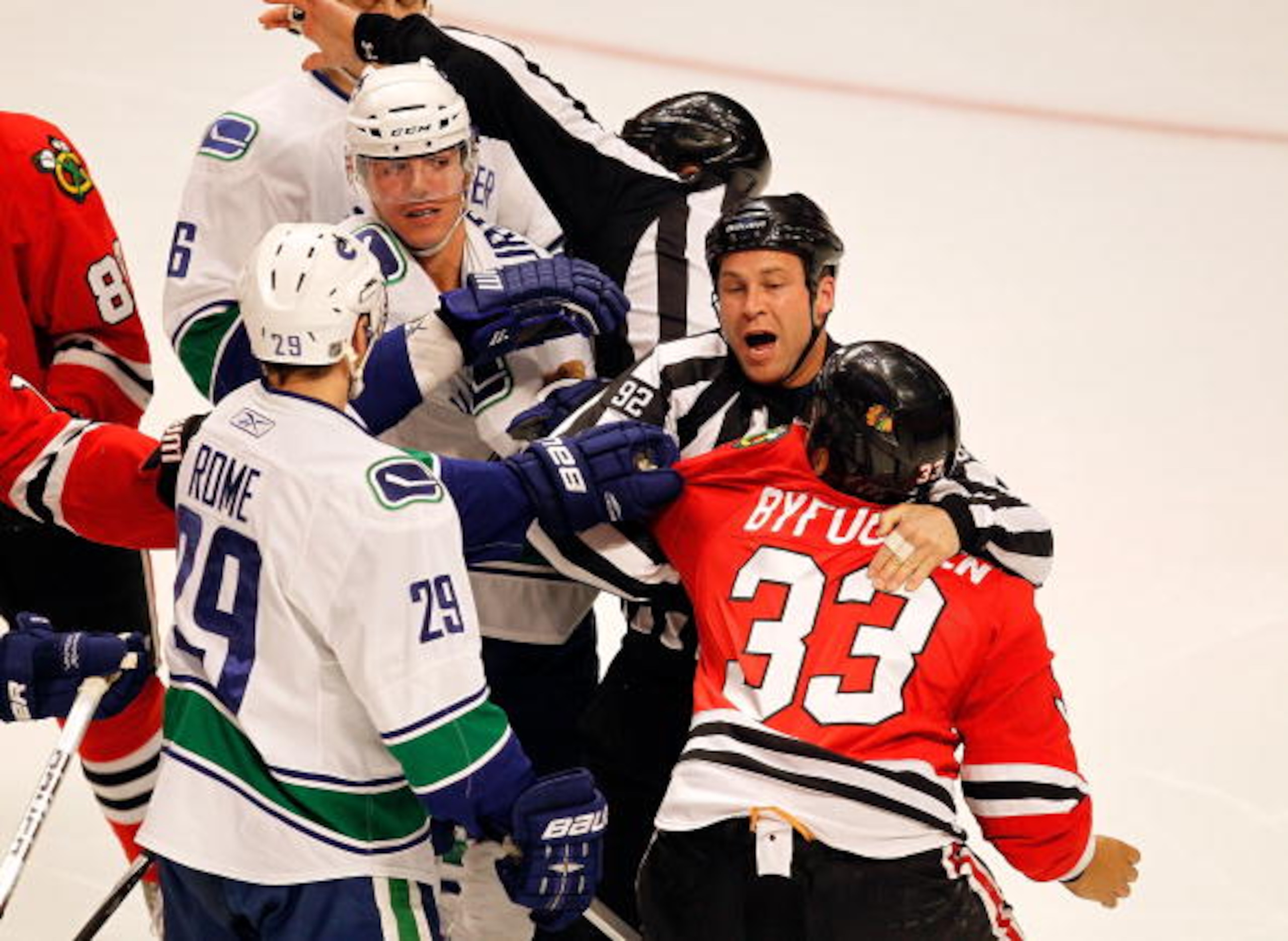 CHICAGO - MARCH 05: Referees try to break up a first period fight between Dustin Byfuglien #33 of the Chicago Blackhawks and Alexander Burrows #14 of the Vancouver Canucks at the United Center on March 5, 2010 in Chicago, Illinois. The Blackhawks defeated CHICAGO - MARCH 05: Referees try to break up a first period fight between Dustin Byfuglien #33 of the Chicago Blackhawks and Alexander Burrows #14 of the Vancouver Canucks at the United Center on March 5, 2010 in Chicago, Illinois. The Blackhawks defeated