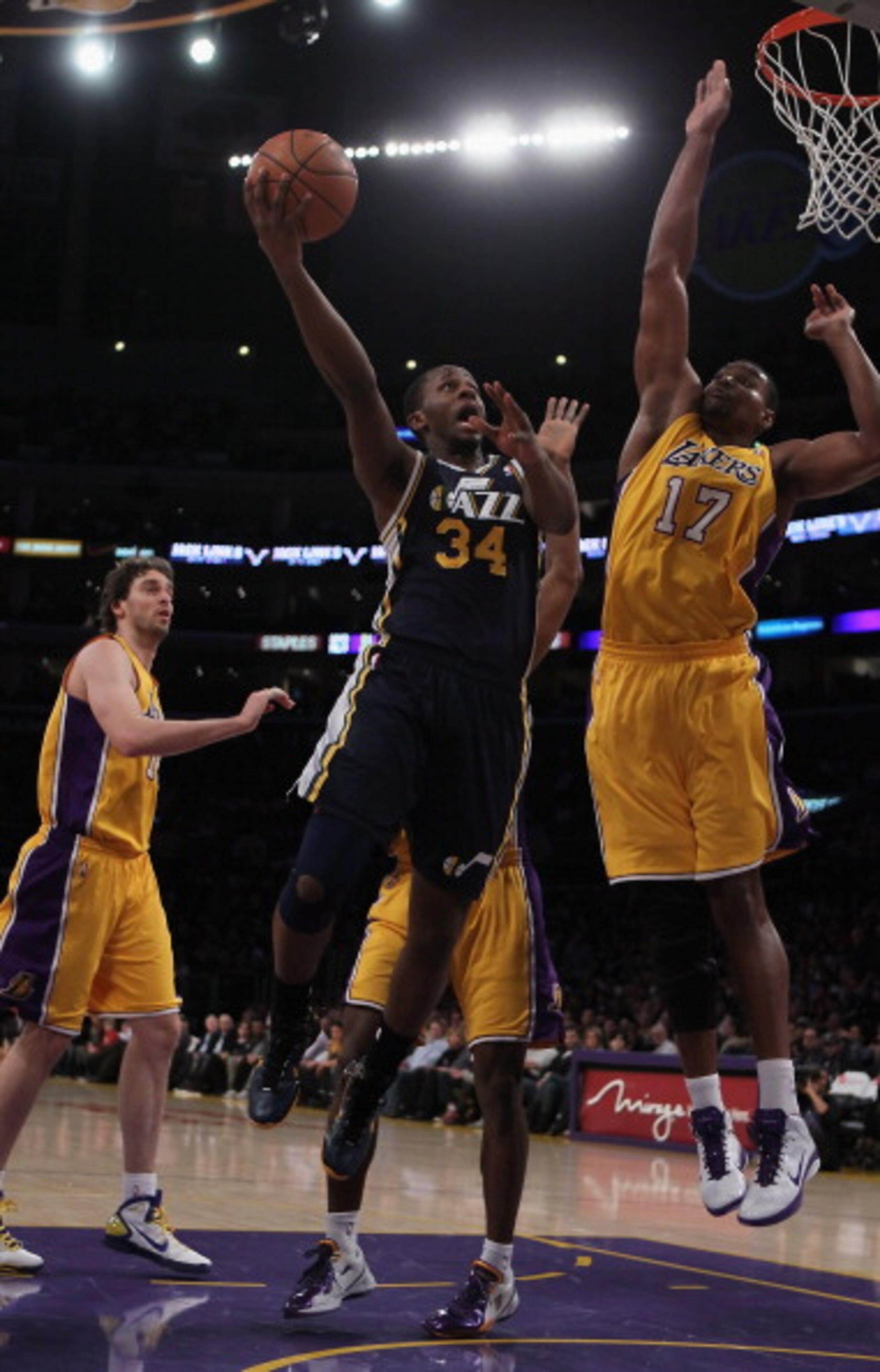 LOS ANGELES, CA - JANUARY 25:  C.J. Miles #34 of the Utah Jazz drives to the basket past Andrew Bynum #17 of the Los Angeles Lakers in the first half at Staples Center on January 25, 2011 in Los Angeles, California. NOTE TO USER: User expressly acknowledg
