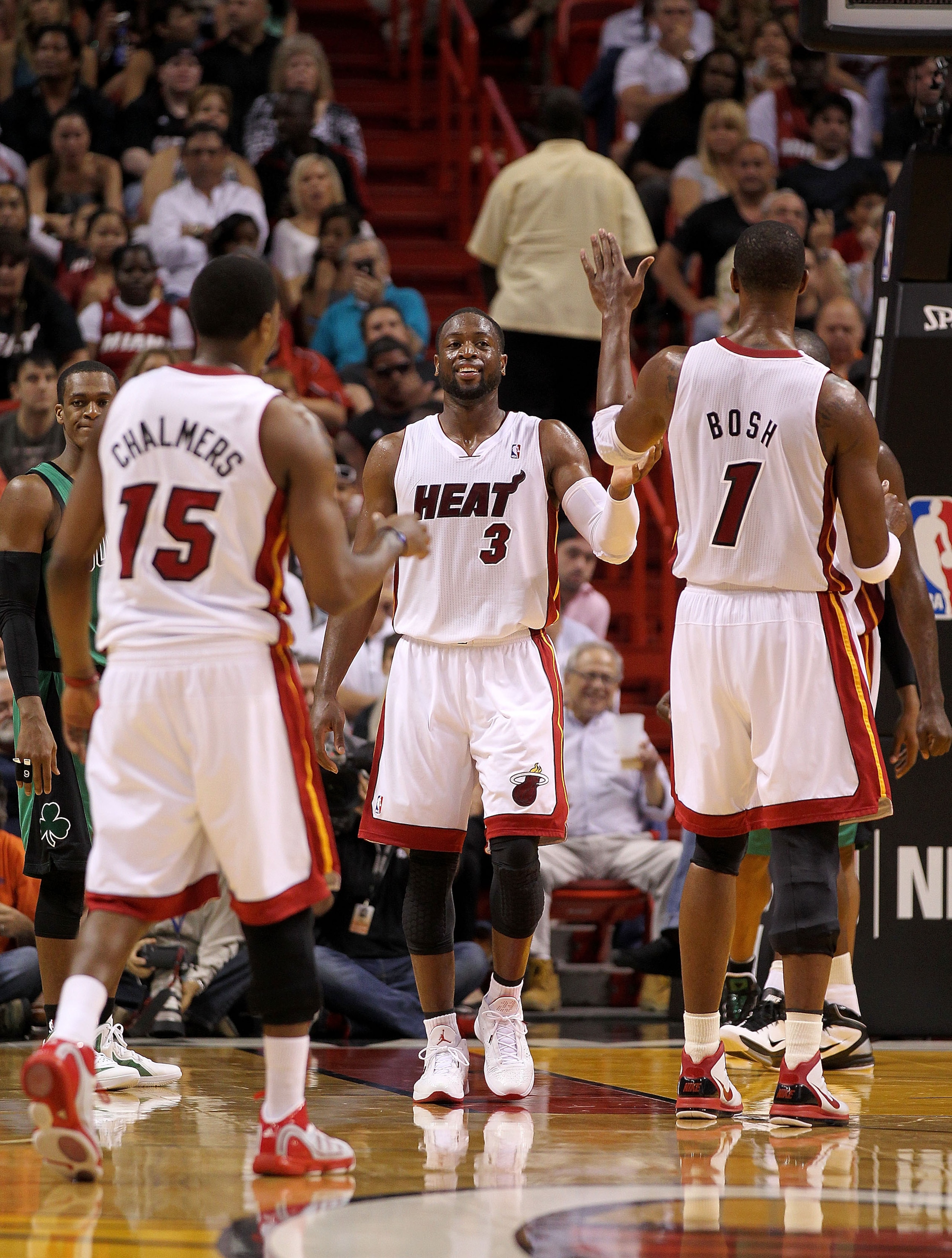 MIAMI, FL - APRIL 10:  Dwyane Wade #3 of the Miami Heat high fives with Chris Bosh #1 and Mario Chalmers #15 during a game against the Boston Celtics at American Airlines Arena on April 10, 2011 in Miami, Florida. NOTE TO USER: User expressly acknowledges
