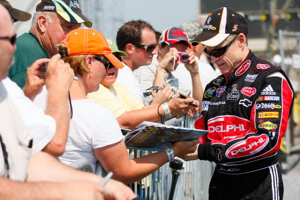 DOVER, DE - SEPTEMBER 24:  Mark Martin (R), driver of the #5 Delphi/GoDaddy.com Chevrolet, signs autographs for fans after practice for the NASCAR Sprint Cup Series AAA 400 at Dover International Speedway on September 24, 2010 in Dover, Delaware.  (Photo