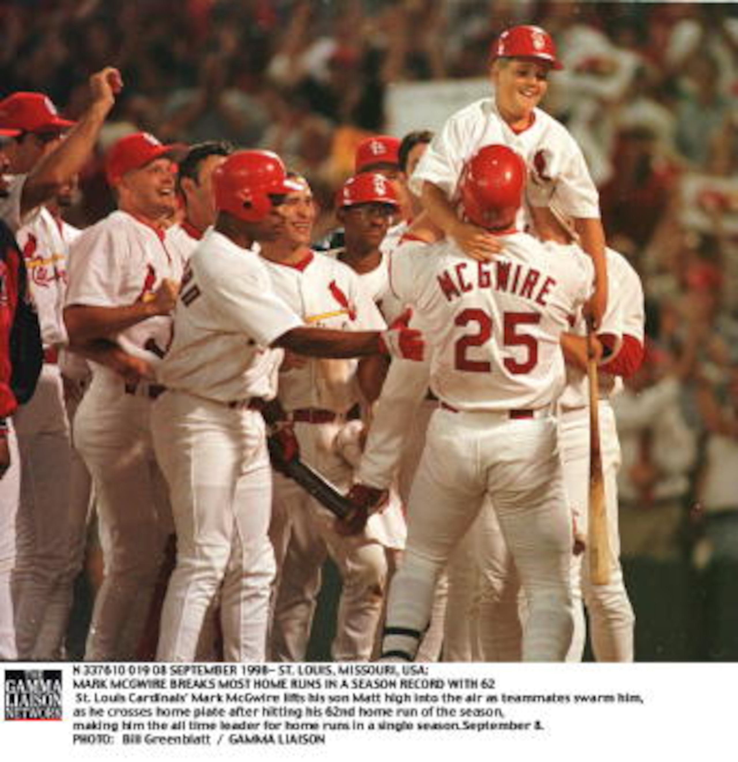 SLP98090819- 08 SEPTEMBER 1998- ST. LOUIS, MISSOURI, USA: St. Louis Cardinals'' Mark McGwire lifts his son Matt high into the air as teammates swarm him, as he crosses home plate after hitting his 62nd home run of the season, making him the all time leade SLP98090819- 08 SEPTEMBER 1998- ST. LOUIS, MISSOURI, USA: St. Louis Cardinals'' Mark McGwire lifts his son Matt high into the air as teammates swarm him, as he crosses home plate after hitting his 62nd home run of the season, making him the all time leade