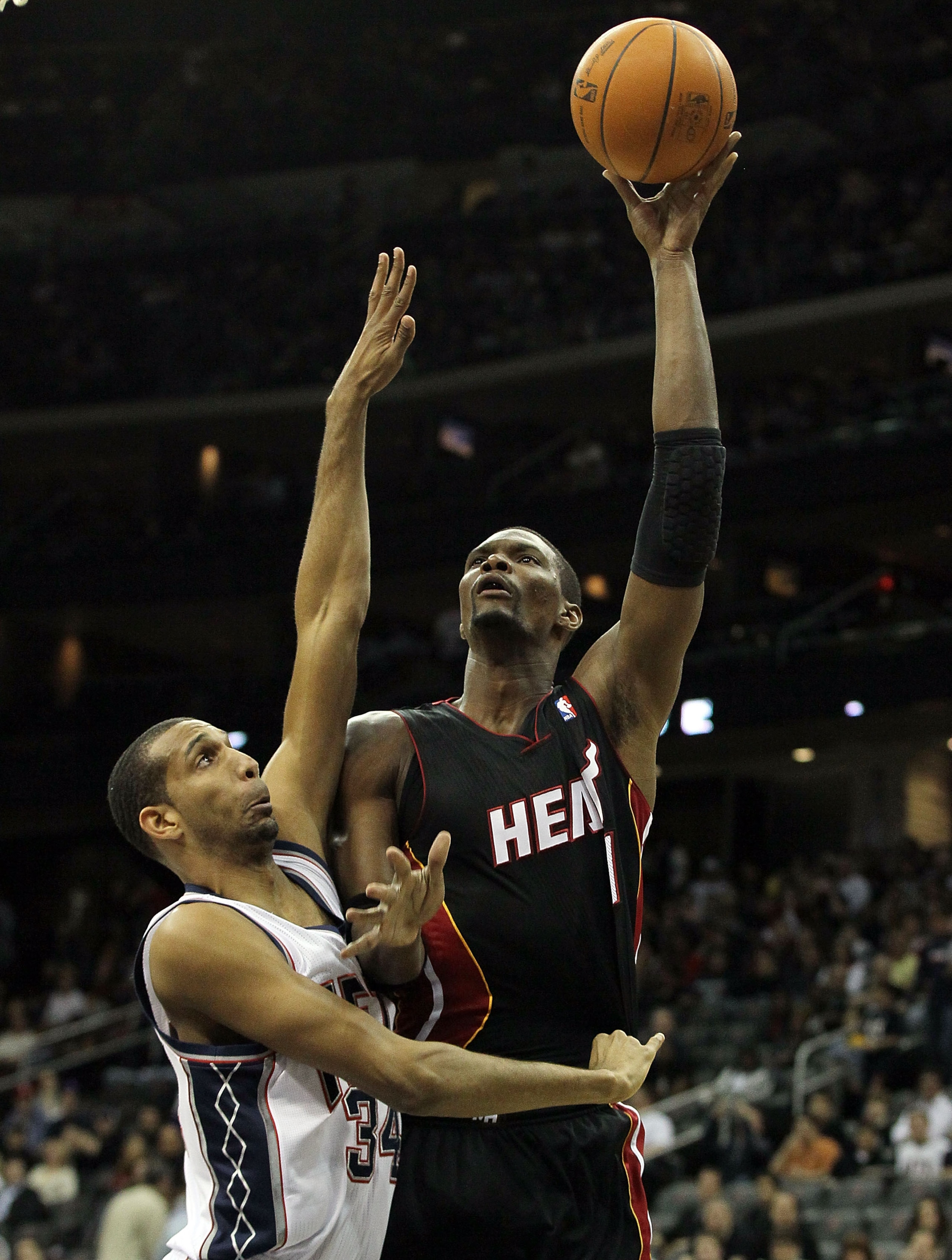 NEWARK, NJ - APRIL 03:  Chris Bosh #1 of the Miami Heat pits up a basket against Brandan Wright #34 of the New Jersey Nets at the Prudential Center on April 3, 2011 in Newark, New Jersey.NOTE TO USER: User expressly acknowledges and agrees that, by downlo
