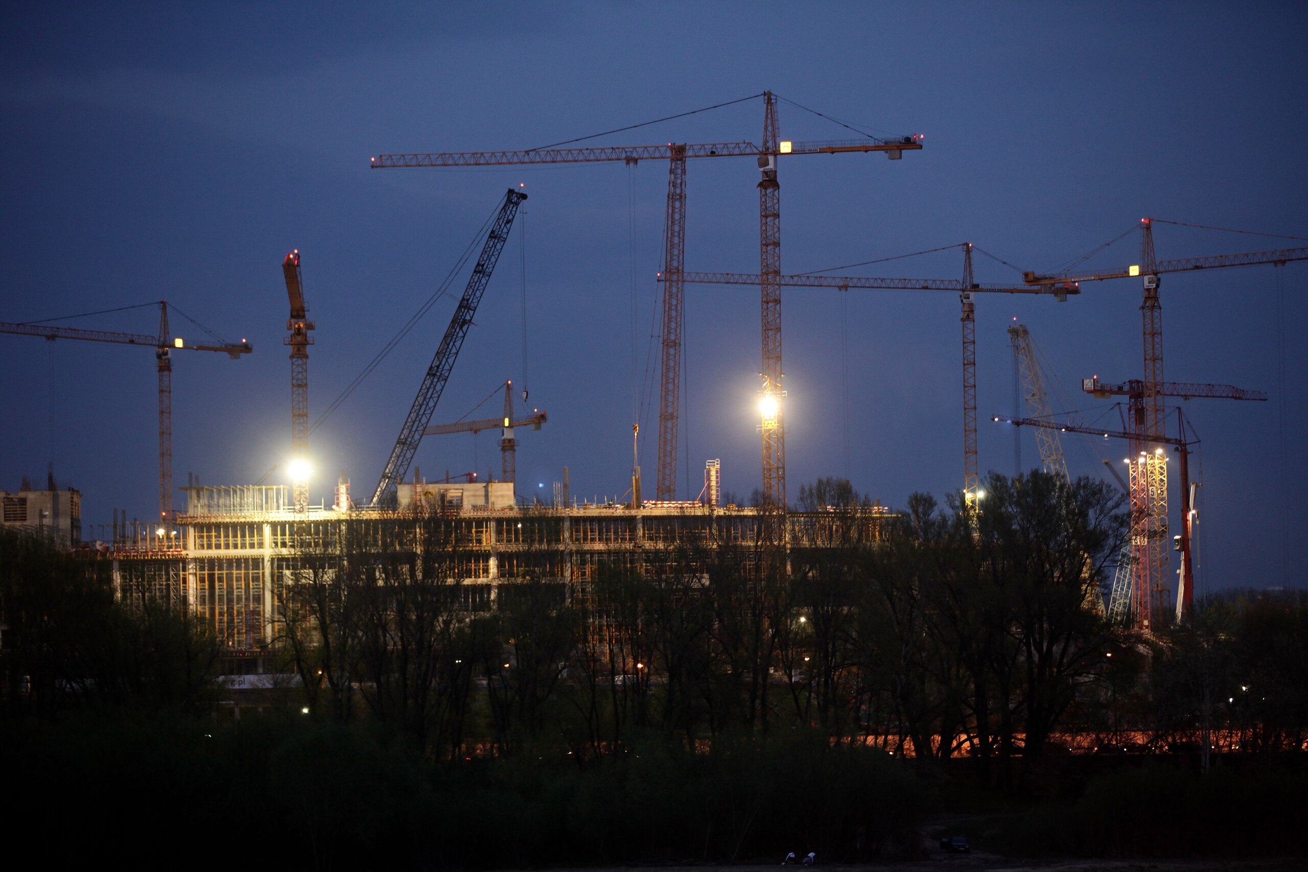 WARSAW, POLAND - APRIL 15: Construction cranes loom over the new National Stadium on April 15, 2010 in Warsaw, Poland. Poland and Ukraine will host the UEFA EURO 2012 football championships, and both countries are investing heavily in infrastructure and WARSAW, POLAND - APRIL 15: Construction cranes loom over the new National Stadium on April 15, 2010 in Warsaw, Poland. Poland and Ukraine will host the UEFA EURO 2012 football championships, and both countries are investing heavily in infrastructure and
