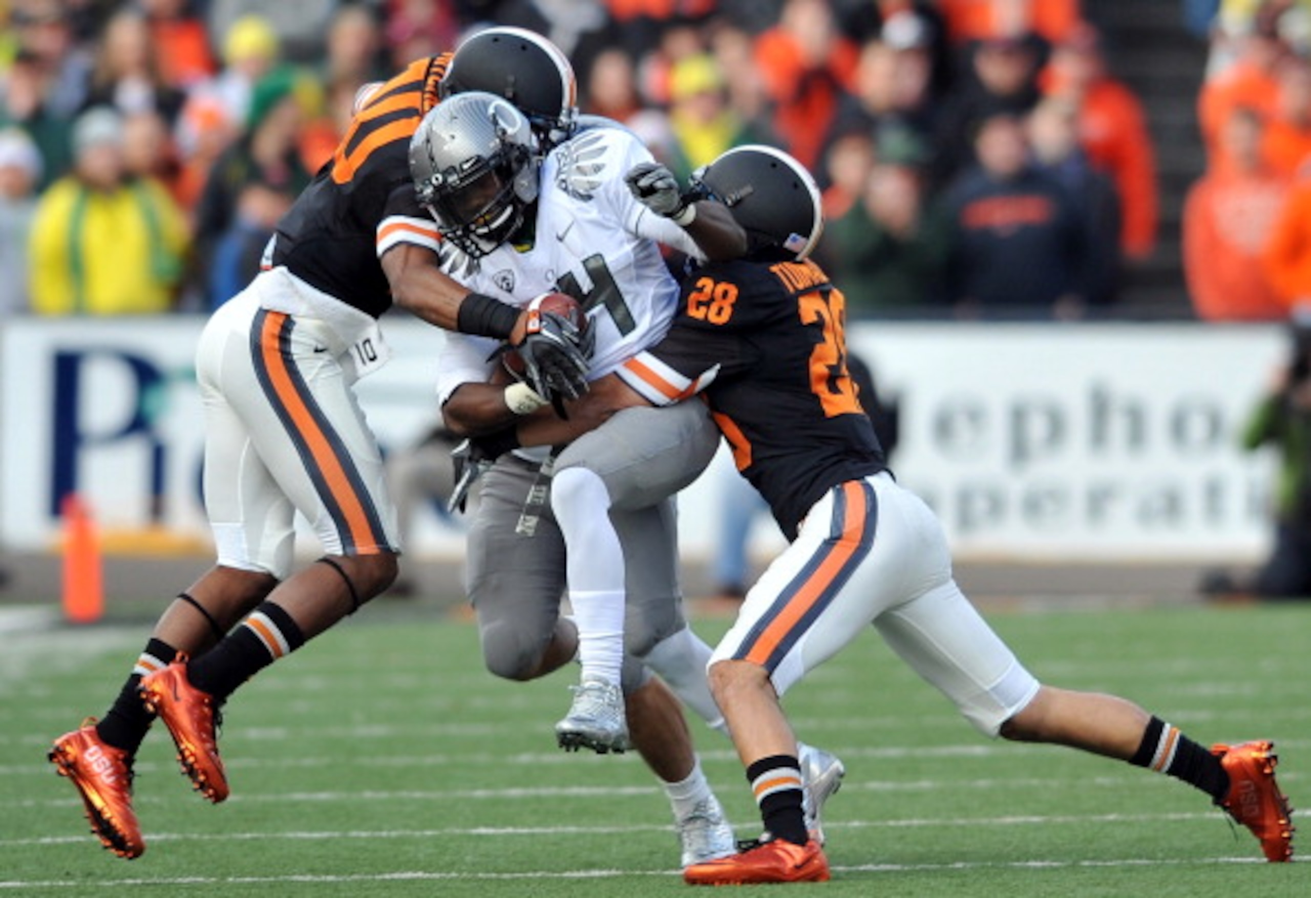 CORVALLIS, OR - DECEMBER 4: Kenjon Barner #24 of the Oregon Ducks struggles for some extra yards as Lance Mitchell #10 and Suaesi Tuimaunei #28 of the Oregon State Beavers in the second quarter of the game at Reser Stadium on December 4, 2010 in Corvallis CORVALLIS, OR - DECEMBER 4: Kenjon Barner #24 of the Oregon Ducks struggles for some extra yards as Lance Mitchell #10 and Suaesi Tuimaunei #28 of the Oregon State Beavers in the second quarter of the game at Reser Stadium on December 4, 2010 in Corvallis