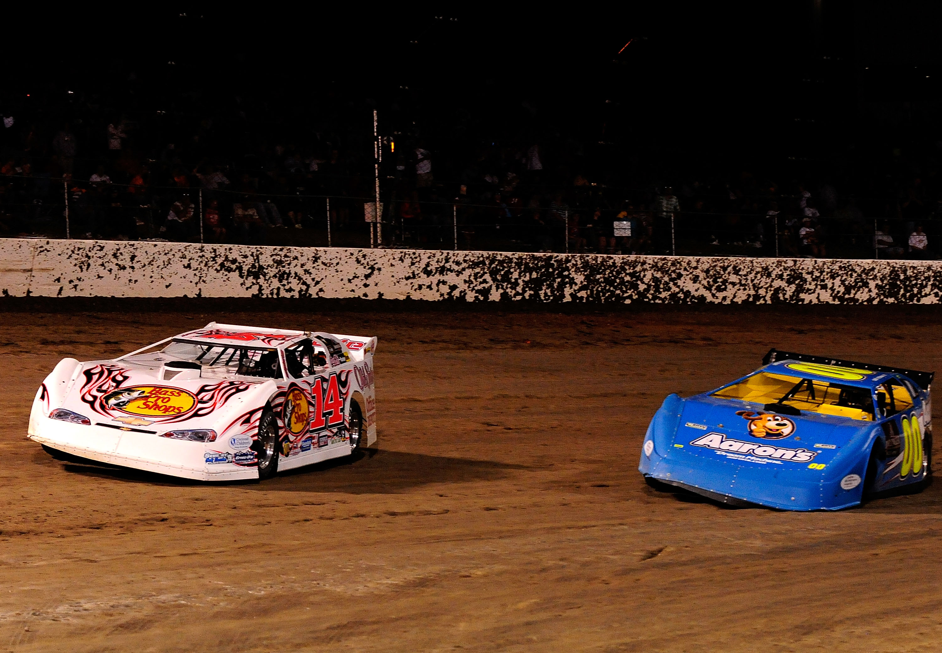 ROSSBURG, OH - JUNE 09: Tony Stewart, driver of the #14 Bass Pro Shops late model Chevrolet, passes David Reutimann, driver of the #00 Aaron's late model Toyota, after Reutimann lost a left front wheel during the Gillette Fusion ProGlide Prelude to the Dr