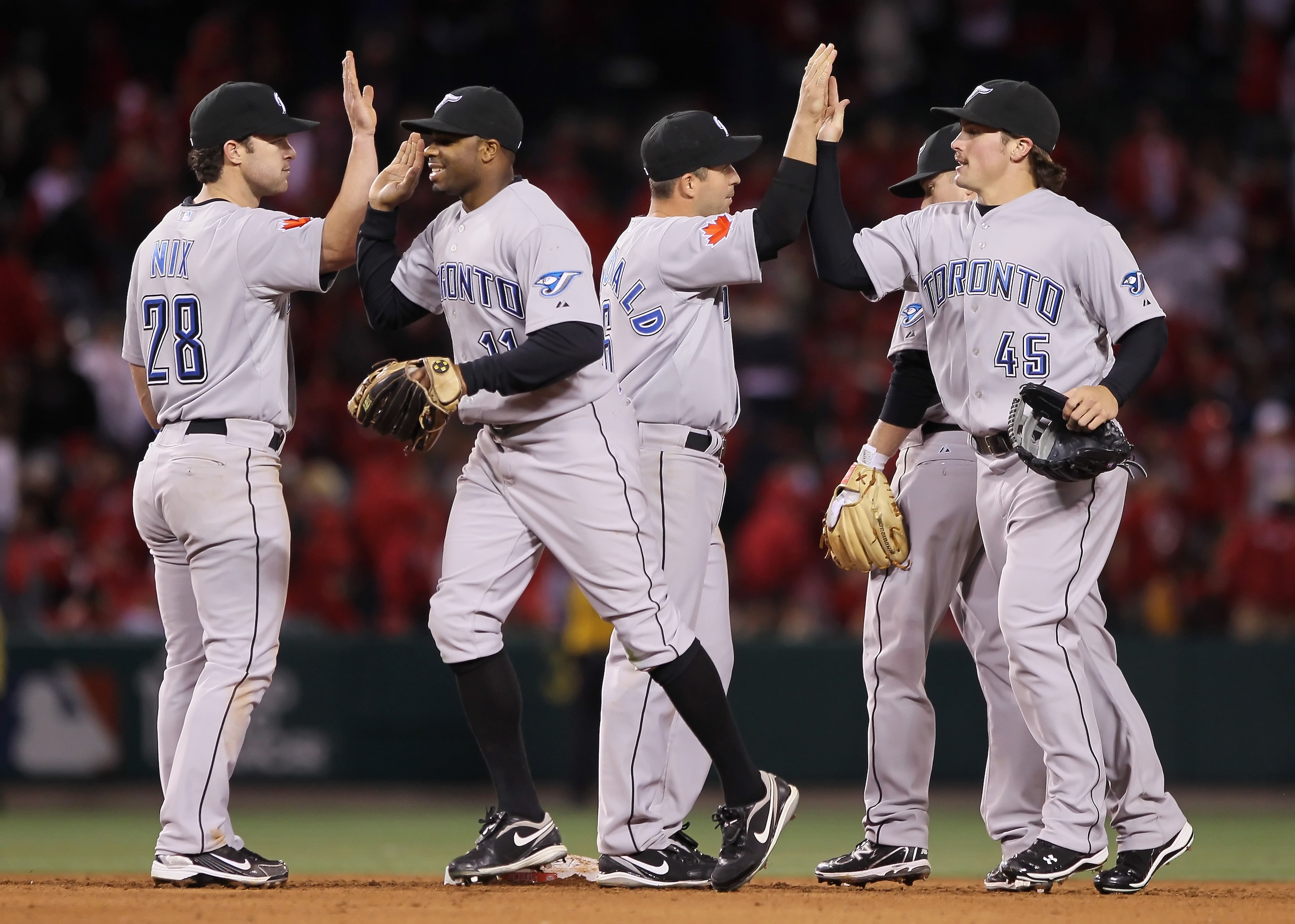 ANAHEIM, CA - APRIL 08:  (L-R) Jayson Nix #28, Rajai Davis #11, John McDonald #6 and Travis Snider #45 of the Toronto Blue Jays celebrate their teams victory over the Los Angeles Angels of Anaheim at Angel Stadium of Anaheim on April 8, 2011 in Anaheim, C