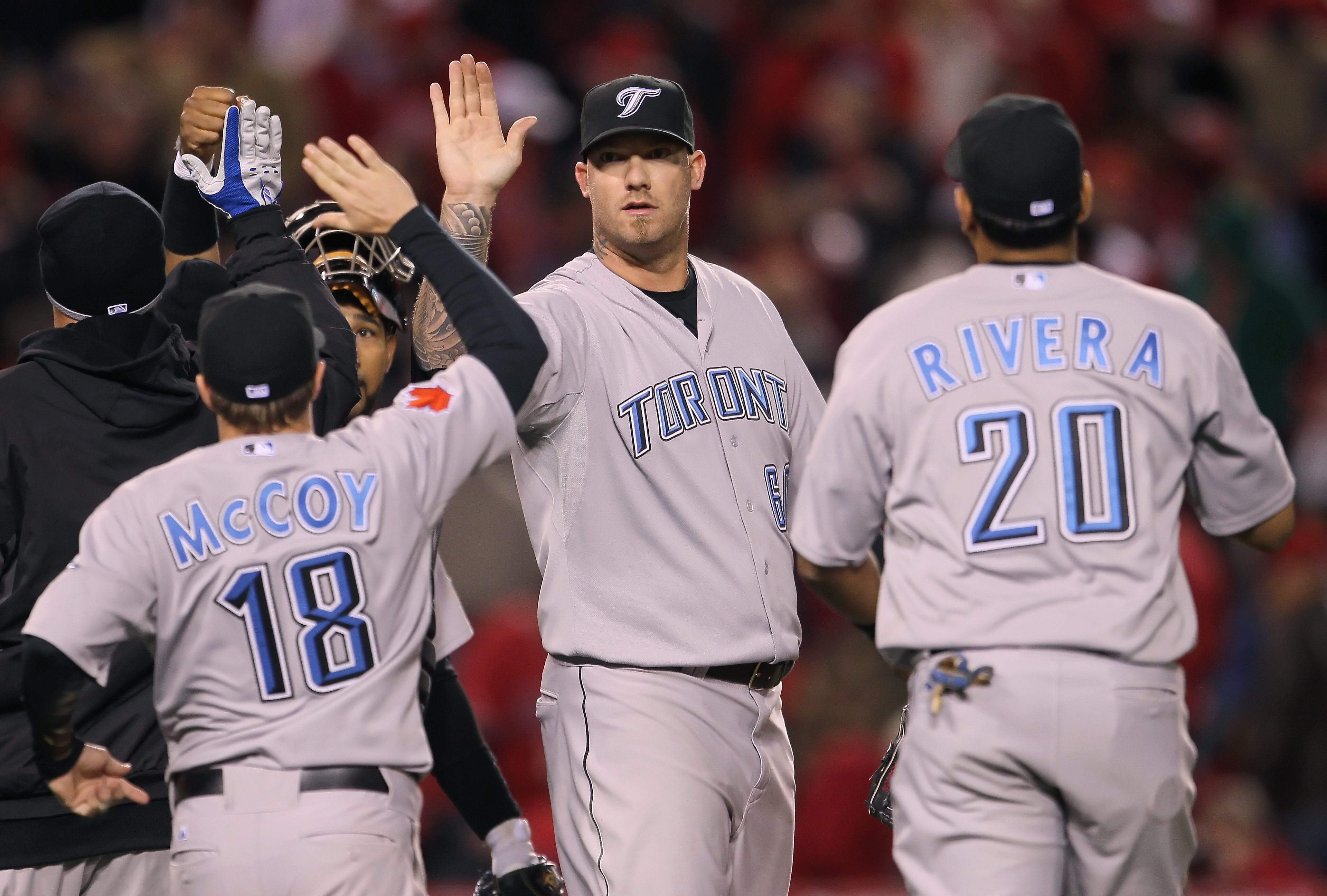 ANAHEIM, CA - APRIL 08:  Closing pitcher Jon Rauch #60 of the Toronto Blue Jays receives high fives from his teammates after saving the game against the Los Angeles Angels of Anaheim at Angel Stadium of Anaheim on April 8, 2011 in Anaheim, California. The