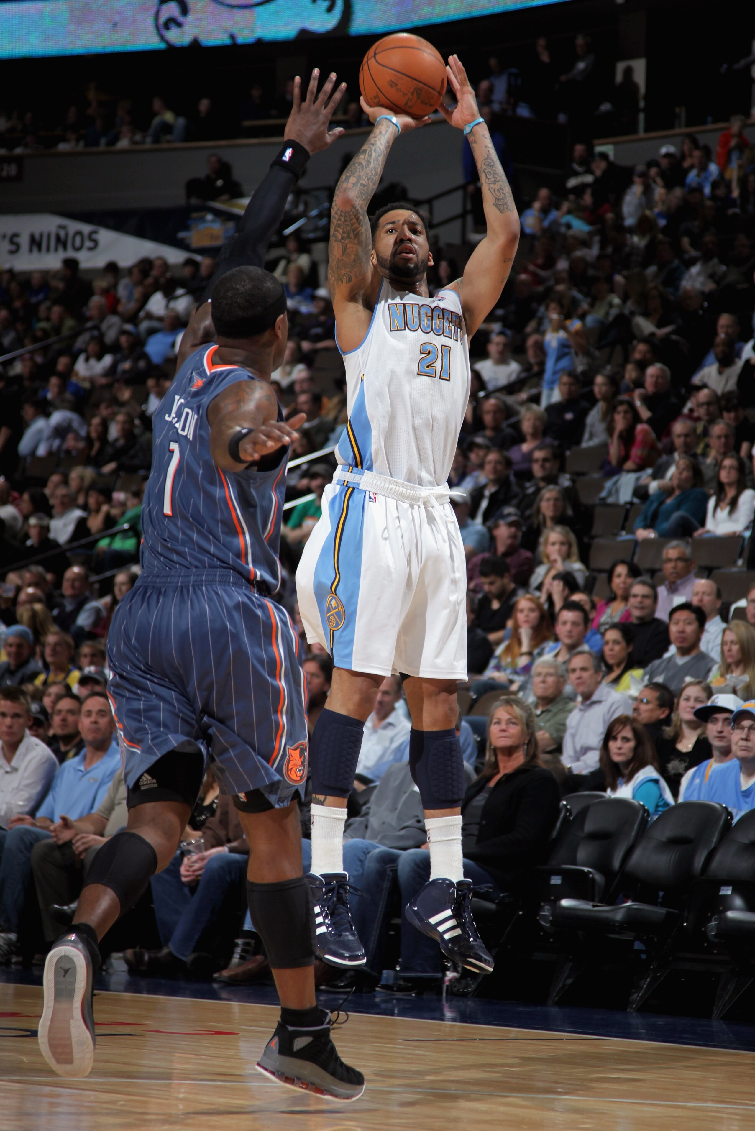DENVER, CO - MARCH 02:  Wilson Chandler #21 of the Denver Nuggets takes a shot over Stephen Jackson #1 of the Charlotte Bobcats at the Pepsi Center on March 2, 2011 in Denver, Colorado. NOTE TO USER: User expressly acknowledges and agrees that, by downloa