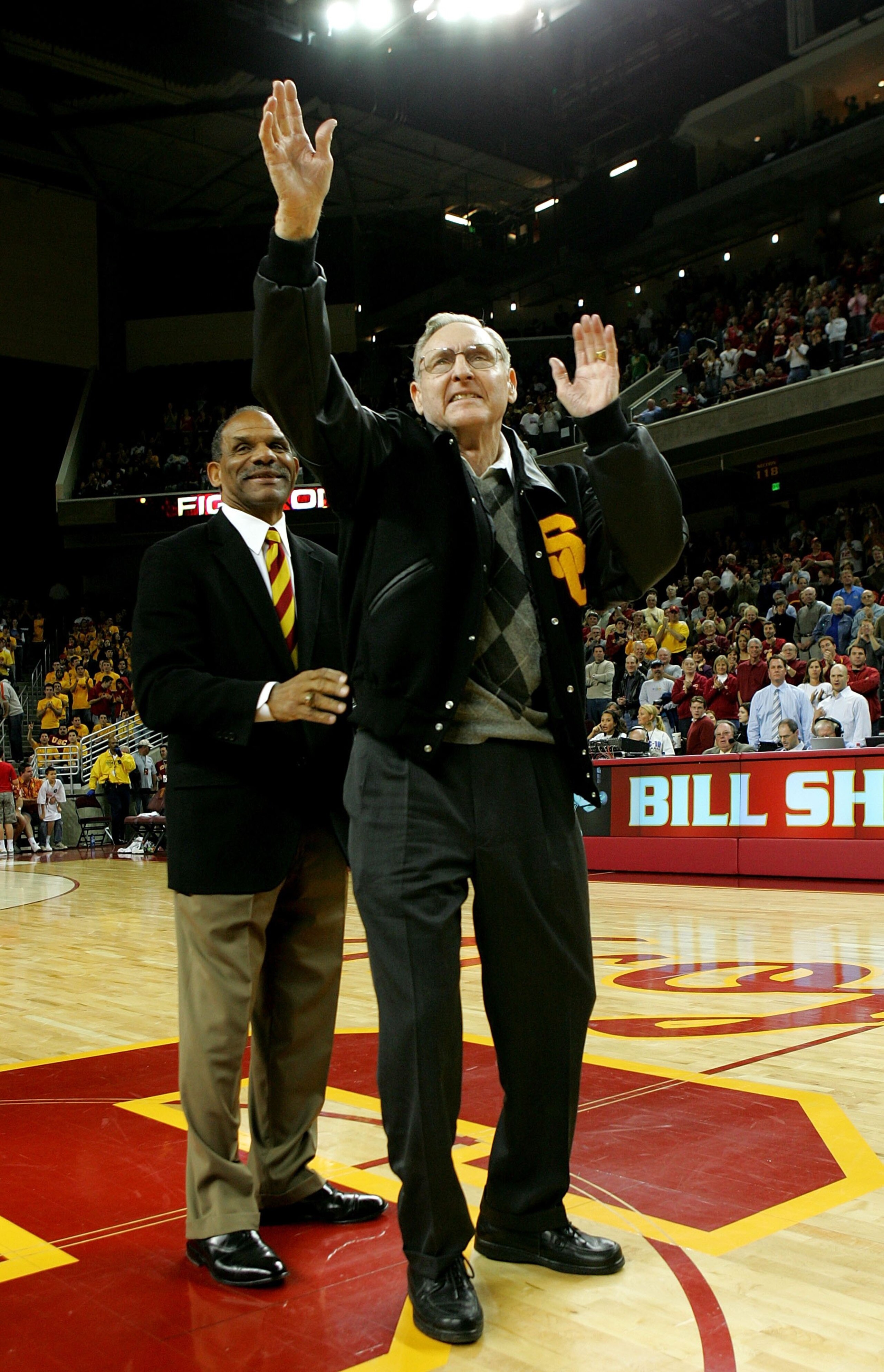 LOS ANGELES - JANUARY 13: Former USC basketball player and Basketball Hall of Fame NBA player and coach Bill Sharman (R) waves to the crowd after being presented with a USC letter jacket by USC Trojans athletic director Mike Garrett during ceremonies to LOS ANGELES - JANUARY 13: Former USC basketball player and Basketball Hall of Fame NBA player and coach Bill Sharman (R) waves to the crowd after being presented with a USC letter jacket by USC Trojans athletic director Mike Garrett during ceremonies to