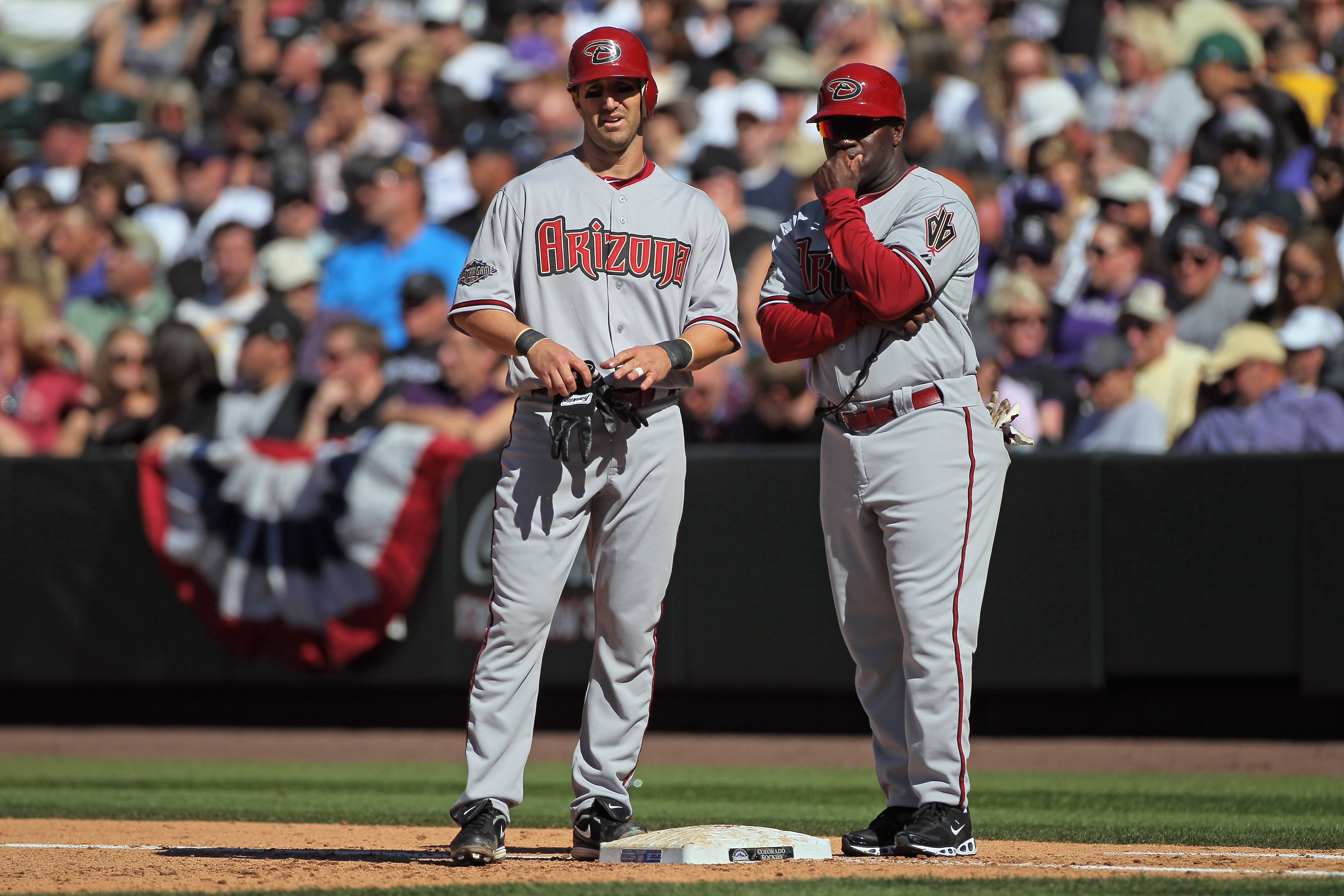 DENVER, CO - APRIL 01:  Firstbase coach Eric Young  of the Arizona Diamondbacks directs Willie Bloomquist #18 of the Arizona Diamondbacks against the Colorado Rockies during Opening Day at Coors Field on April 1, 2011 in Denver, Colorado. The Diamondbacks