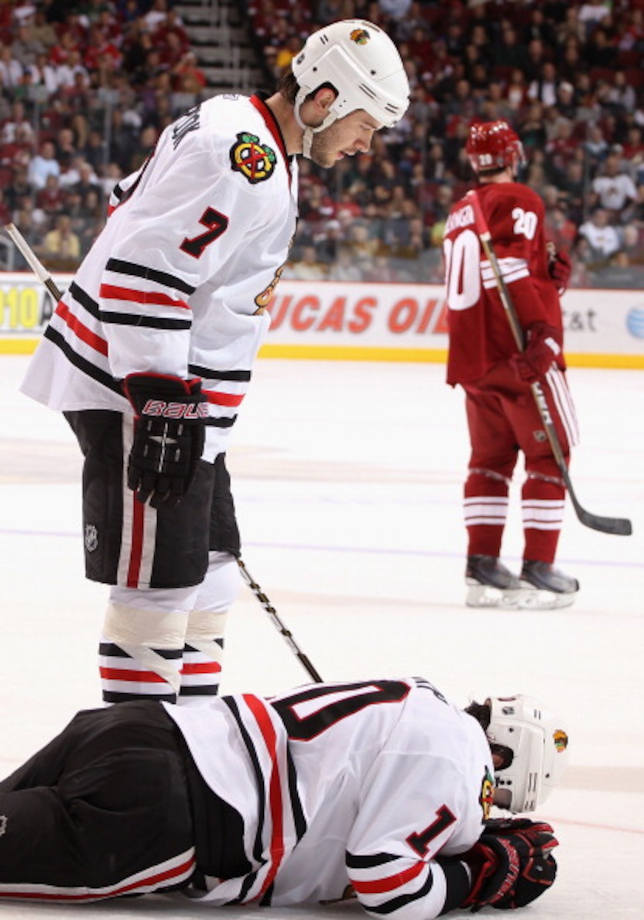 GLENDALE, AZ - MARCH 20:  Patrick Sharp #10 of the Chicago Blackhawks lays on the ice after an injury as Brent Seabrook #7 looks down during the first period of the NHL game against the Phoenix Coyotes at Jobing.com Arena on March 20, 2011 in Glendale, Ar