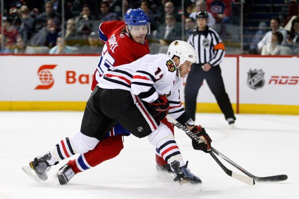 MONTREAL, CANADA - APRIL 5:  Brent Sopel #55 of the Montreal Canadiens defends against Ryan Johnson #17 of the Chicago Blackhawks during the NHL game at the Bell Centre on April 5, 2011 in Montreal, Quebec, Canada.  (Photo by Richard Wolowicz/Getty Images