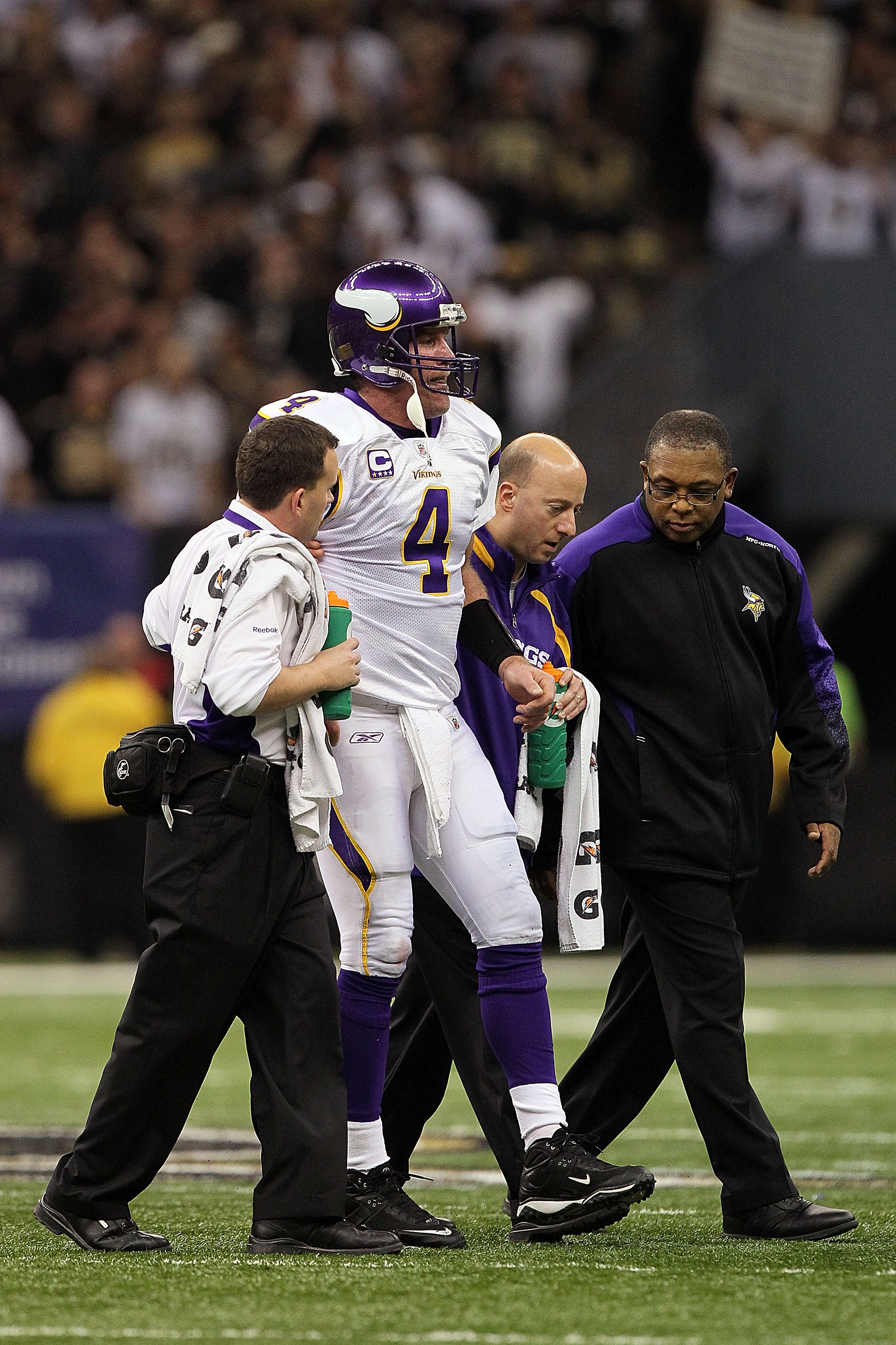 NEW ORLEANS - JANUARY 24:  Brett Favre #4 of  the Minnesota Vikings is helped off the field by medical staff after getting injured on a play against the New Orleans Saints during the NFC Championship Game at the Louisiana Superdome on January 24, 2010 in