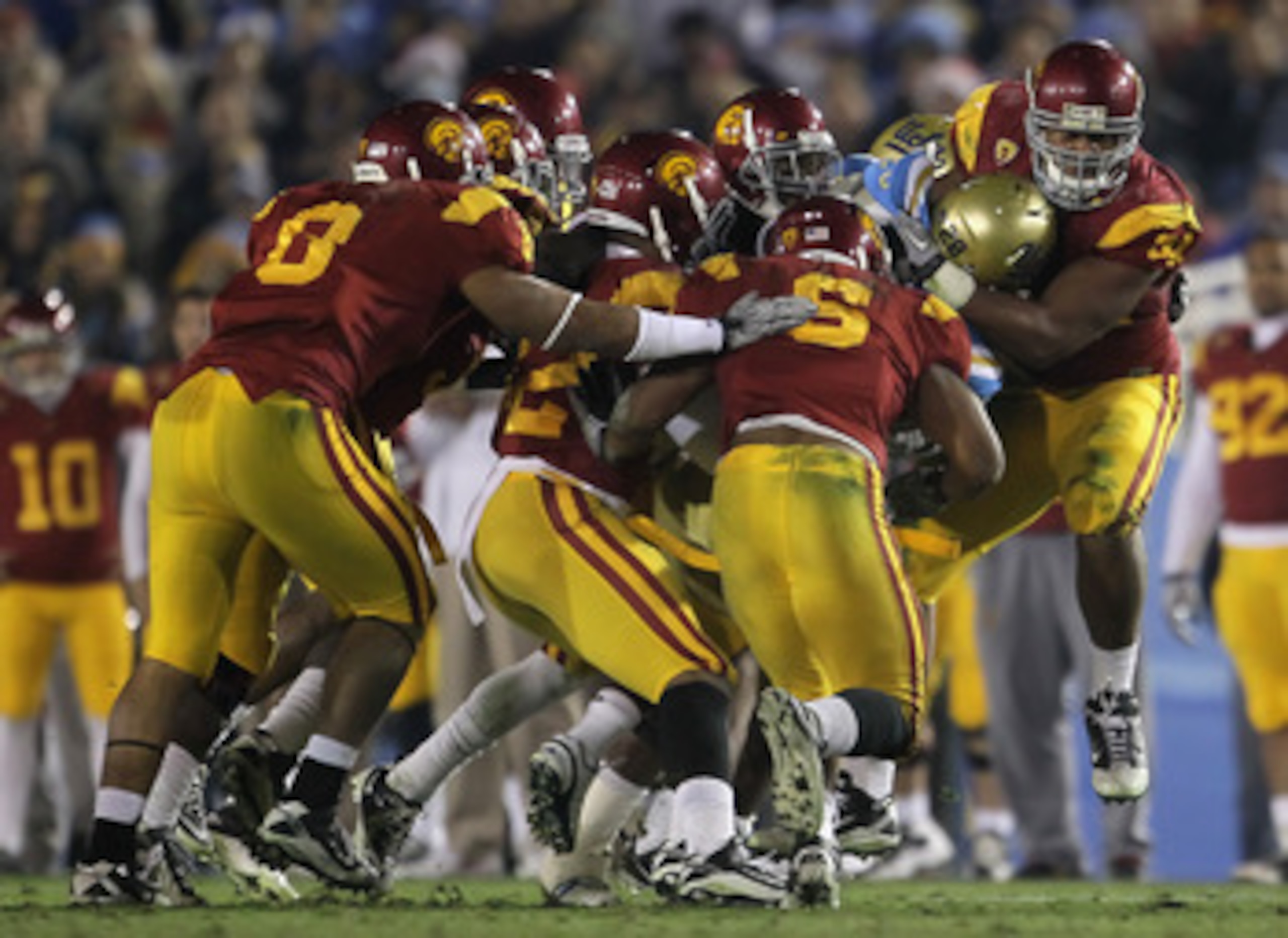 PASADENA, CA - DECEMBER 04:  Chris Galippo (R) #54 of the USC Trojans tackles Malcolm Jones #28 of the UCLA Bruins during the second half at the Rose Bowl on December 4, 2010 in Pasadena, California. USC defeated UCLA 28-14.  (Photo by Jeff Gross/Getty Im