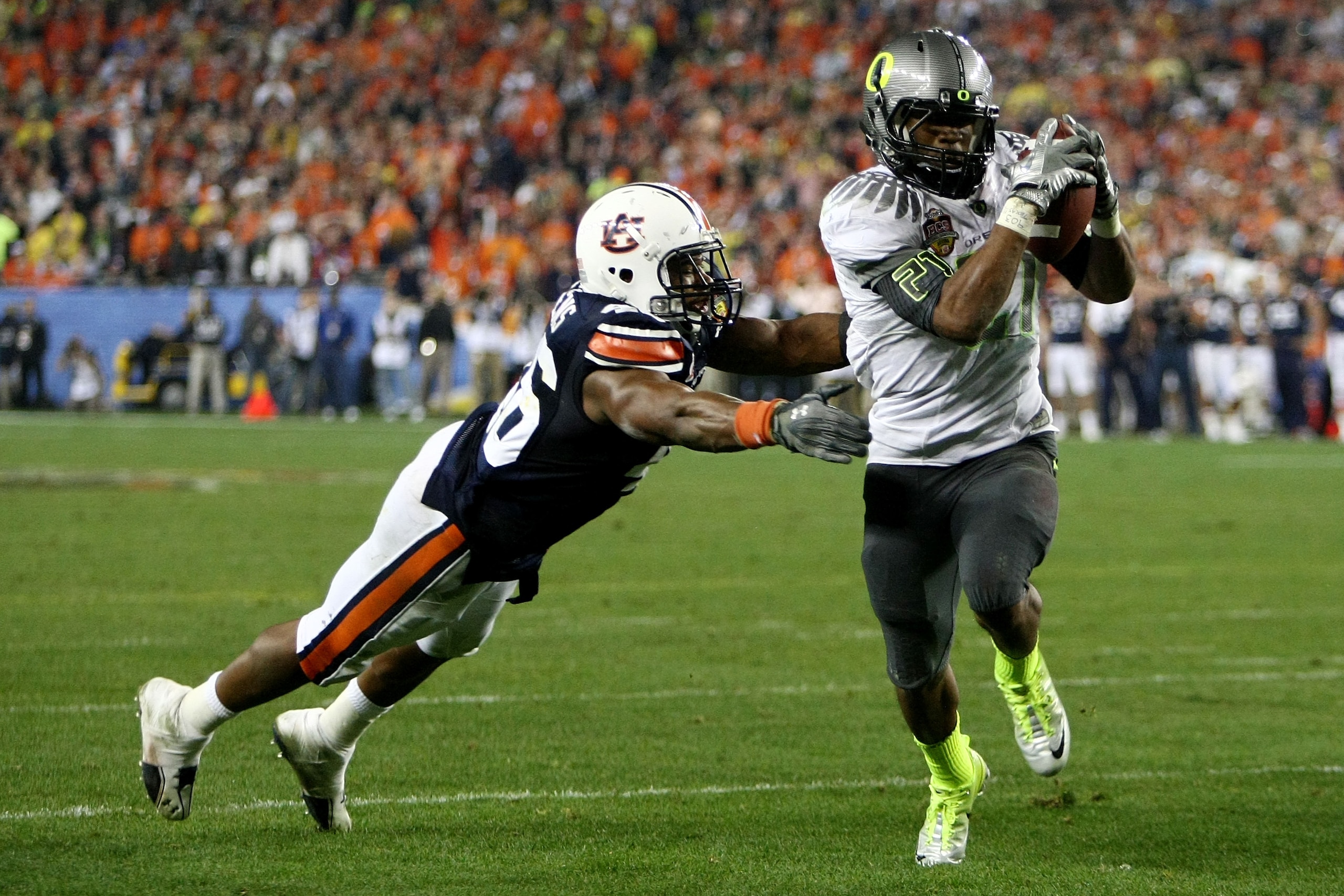 GLENDALE, AZ - JANUARY 10:  Running back LaMichael James #21 of the Oregon Ducks scores a touchdown on a two-yard touchdown reception in front of Craig Stevens #46 of the Auburn Tigers in the fourth quarter during the Tostitos BCS National Championship Ga