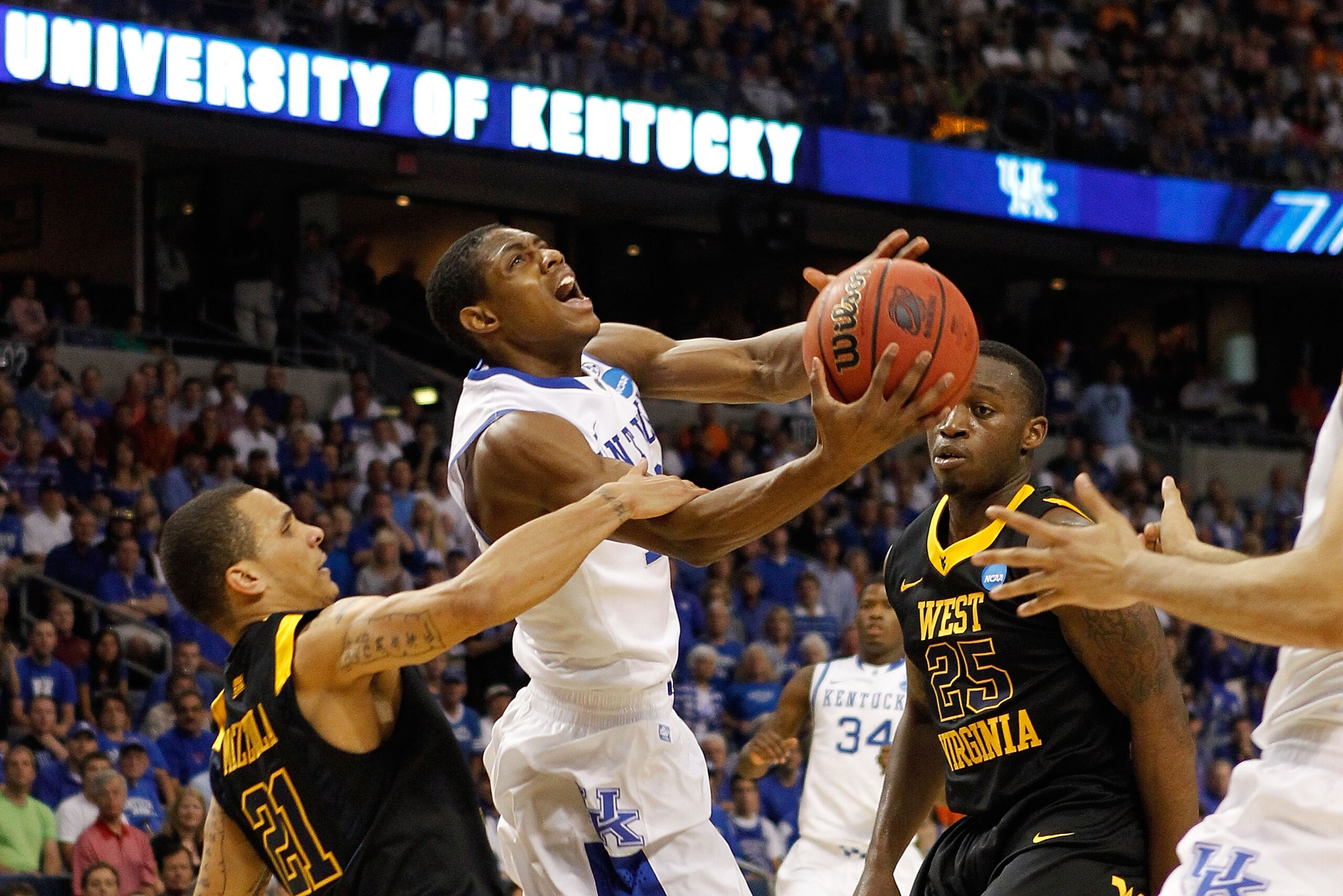 TAMPA, FL - MARCH 19:  Brandon Knight #12 of the Kentucky Wildcats drives to the basket against Joe Mazzulla #21 and Darryl Bryant #25 of the West Virginia Mountaineers during the third round of the 2011 NCAA men's basketball tournament at St. Pete Times