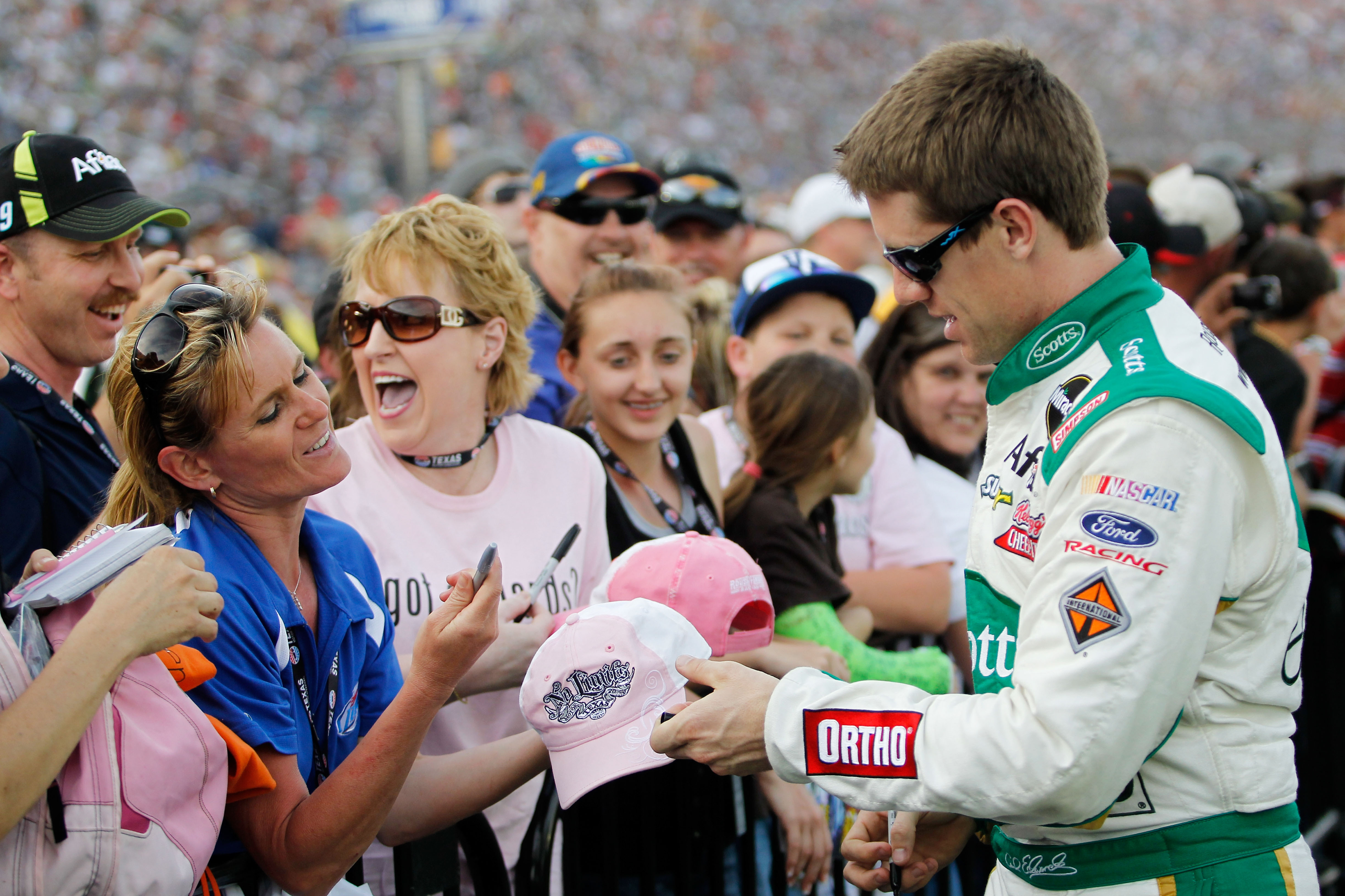 FORT WORTH, TX - APRIL 09:  Carl Edwards (R), driver of the #99 Scotts Ford, signs his autograph for fans prior to the NASCAR Sprint Cup Series Samsung Mobile 500 at Texas Motor Speedway on April 9, 2011 in Fort Worth, Texas.  (Photo by Tom Pennington/Get