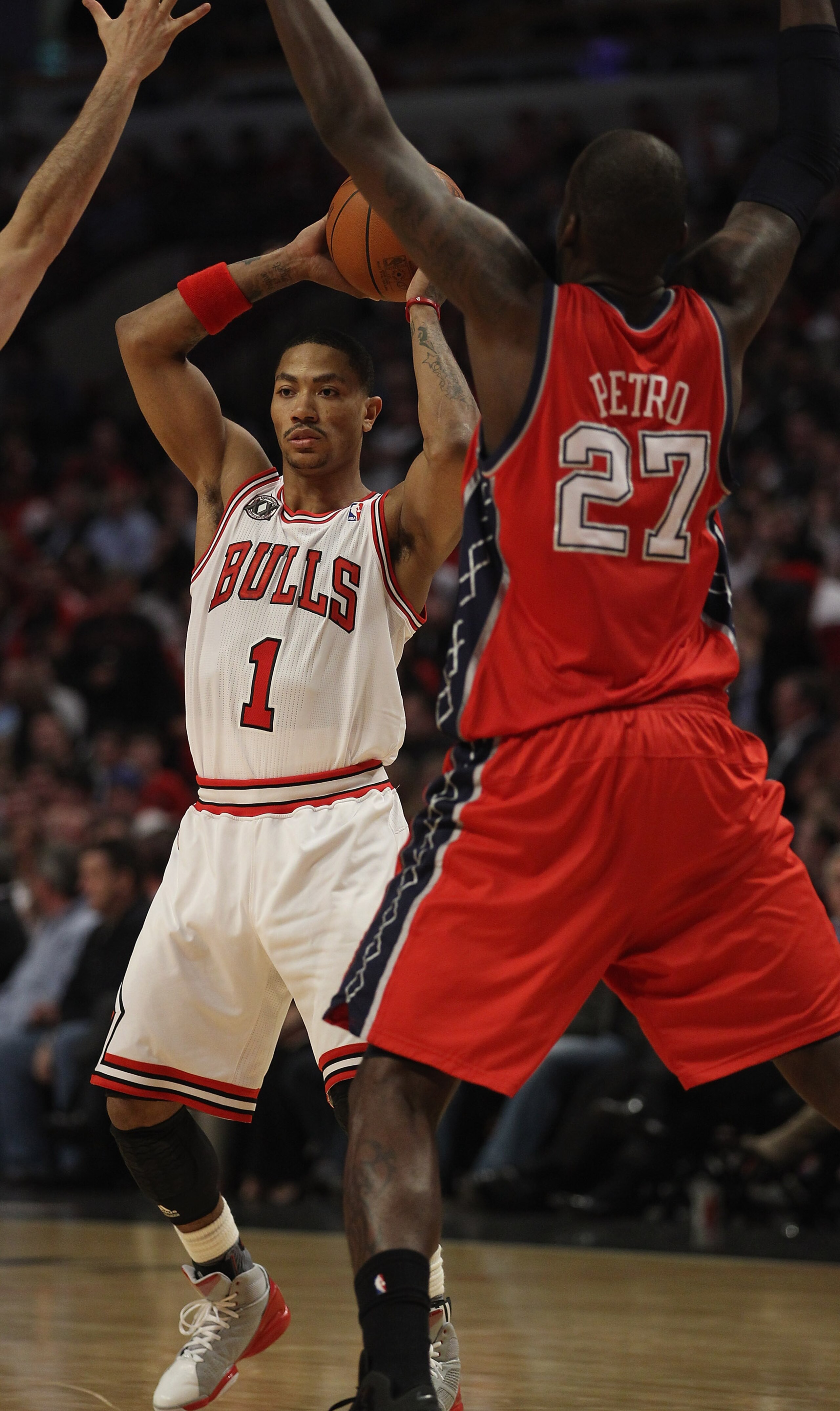CHICAGO, IL - APRIL 13: Derrick Rose #1 of the Chicago Bulls looks to pass against Johan Petro #27 of the New Jersey Nets at the United Center on April 13, 2011 in Chicago, Illinois. The Bulls defeated the Nets 97-92. NOTE TO USER: User expressly acknowle