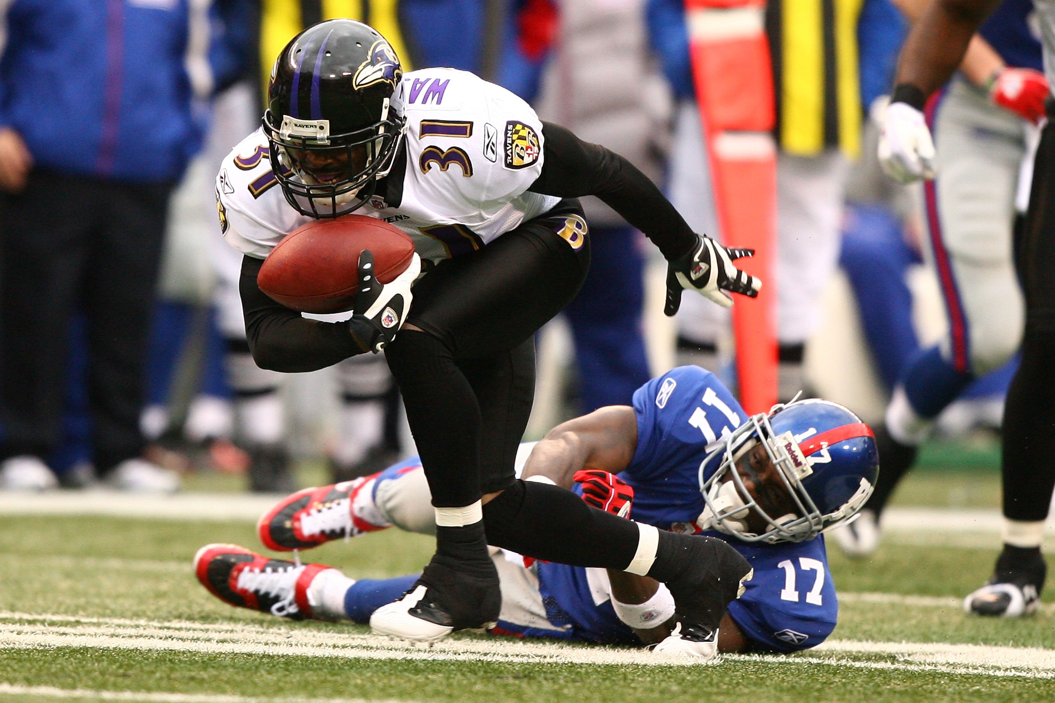 EAST RUTHERFORD, NJ - NOVEMBER 16:  Fabian Washington #31 of the Baltimore Ravens intercepts the ball as Plaxico Burress #17 of The New York Giants misses the tackle during their game on November 16, 2008 at Giants Stadium in East Rutherford, New Jersey.
