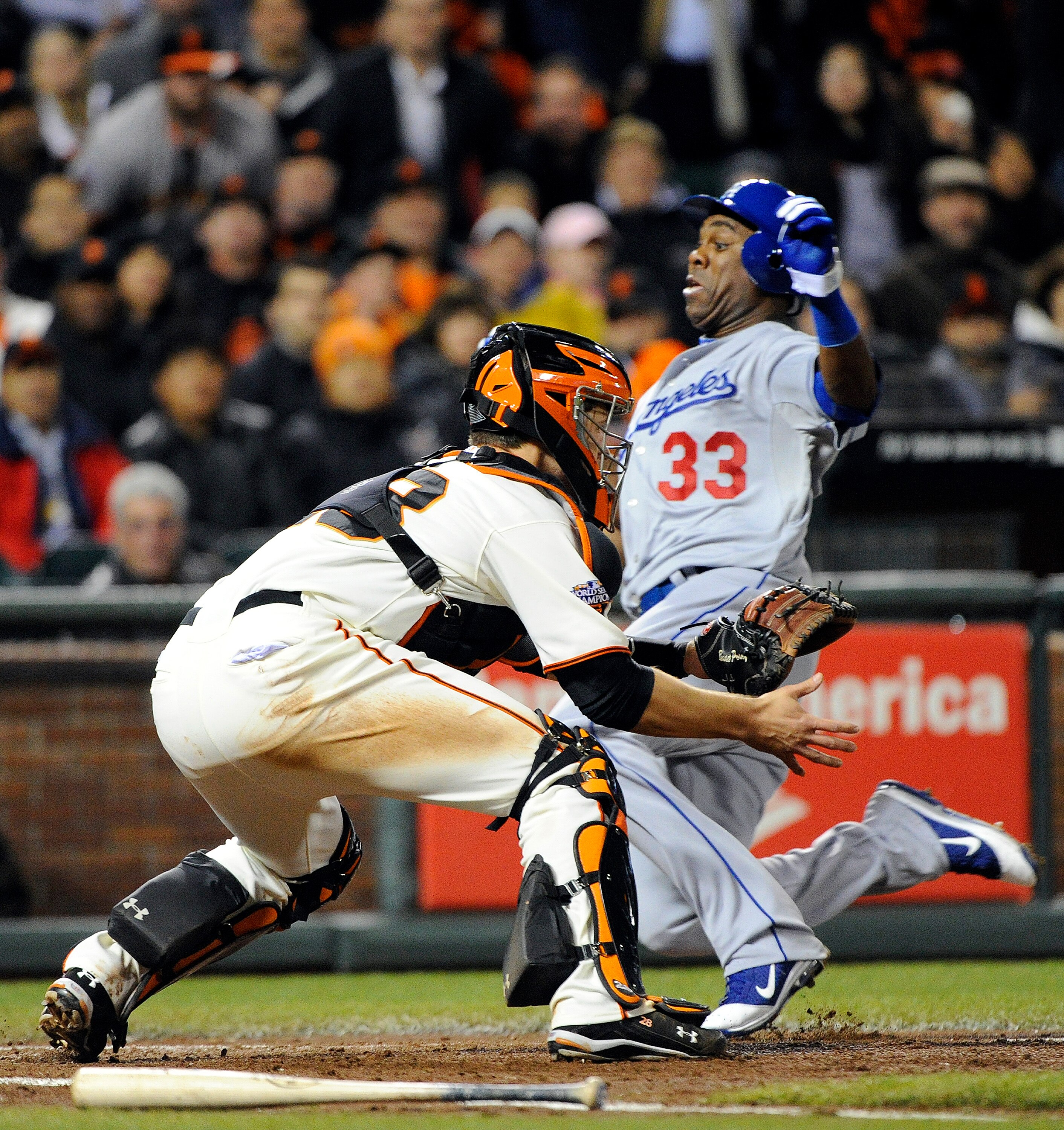 SAN FRANCISCO, CA - APRIL 13: Marcus Thames #33 of the Los Angeles Dodgers slides safely at home plate, beating the throw to Buster Posey #28 of the San Francisco Giants during a MLB baseball game at AT&T Park April 13, 2011 in San Francisco, California.