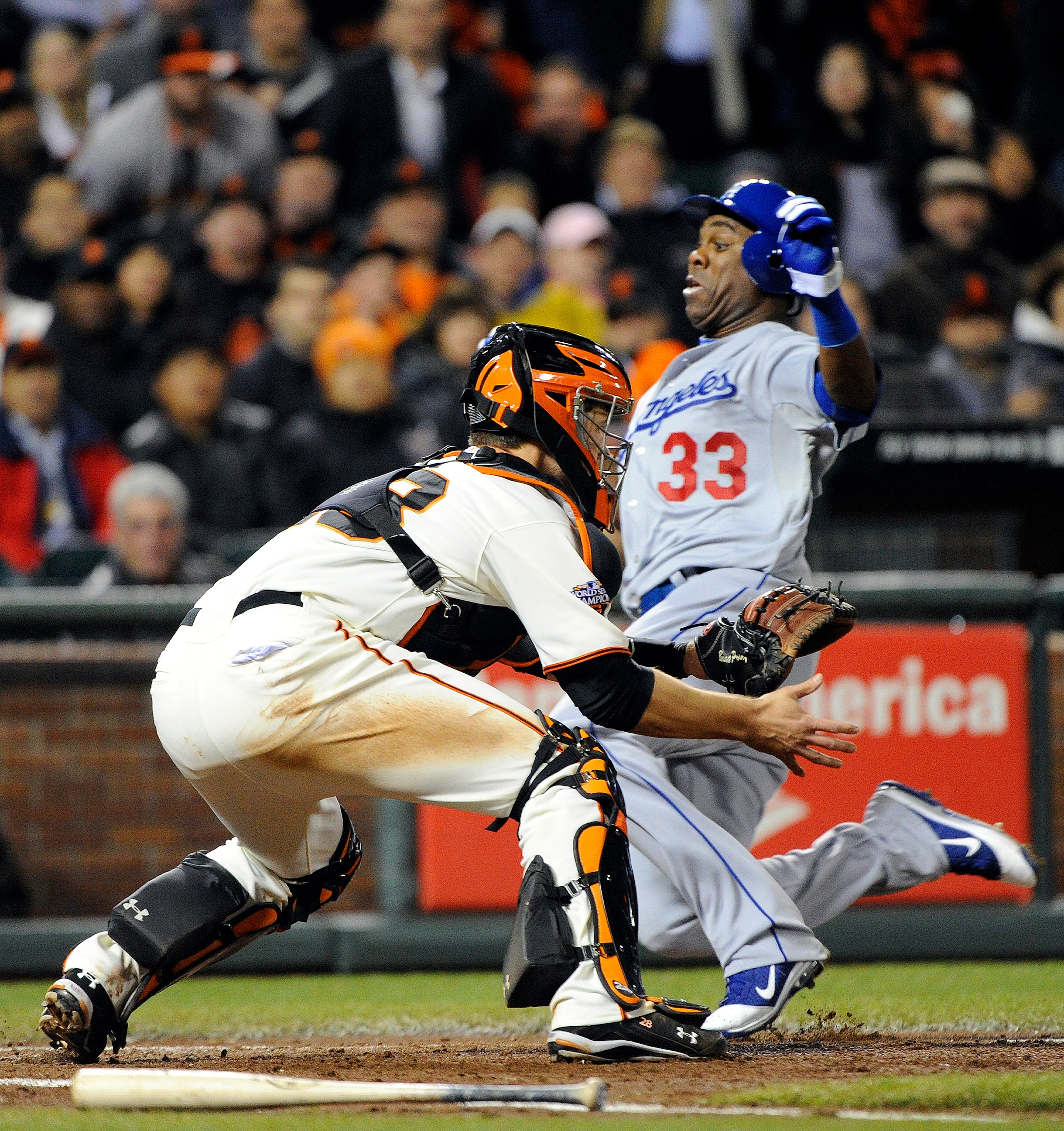 SAN FRANCISCO, CA - APRIL 13: Marcus Thames #33 of the Los Angeles Dodgers slides safely at home plate, beating the throw to Buster Posey #28 of the San Francisco Giants during a MLB baseball game at AT&T Park April 13, 2011 in San Francisco, California.