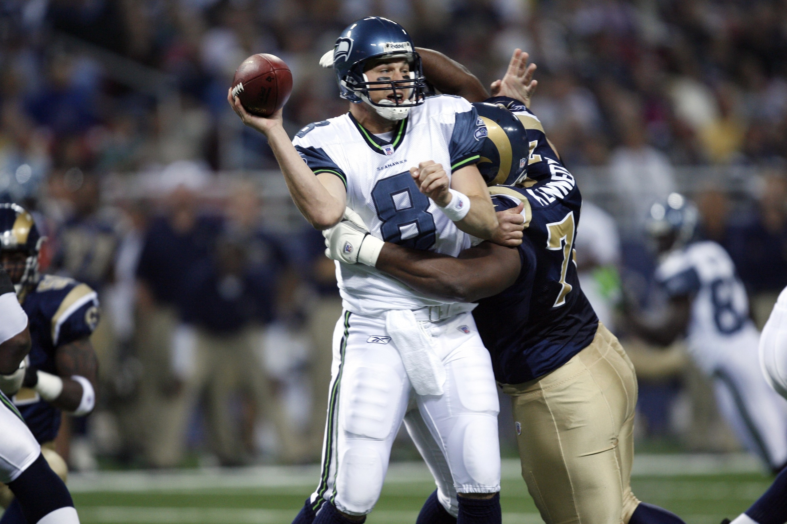 ST. LOUIS, MO ? OCTOBER 15:  Quarterback Matt Hasselbeck #8 of the Seattle Seahawks passes the ball while being tackled by nose tackle Jimmy Kennedy #73 of the St. Louis Rams during the game at Edward Jones Dome in St. Louis, Missouri on October 15, 2006.
