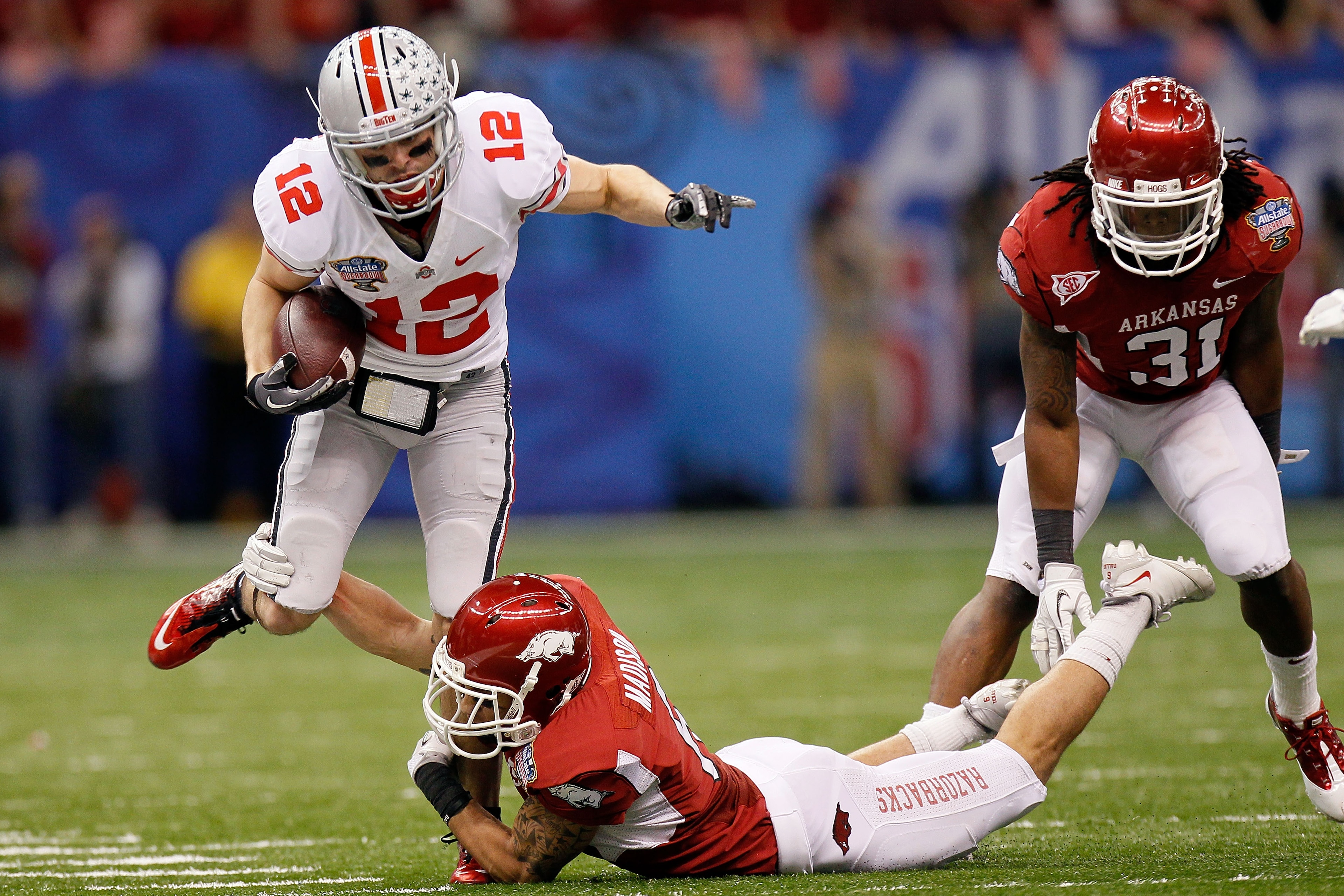 NEW ORLEANS, LA - JANUARY 04:  Dane Sanzenbacher #12 of the Ohio State Buckeyes runs after a catch against Isaac Madison #6 of the Arkansas Razorbacks in the second quarter during the Allstate Sugar Bowl at the Louisiana Superdome on January 4, 2011 in Ne