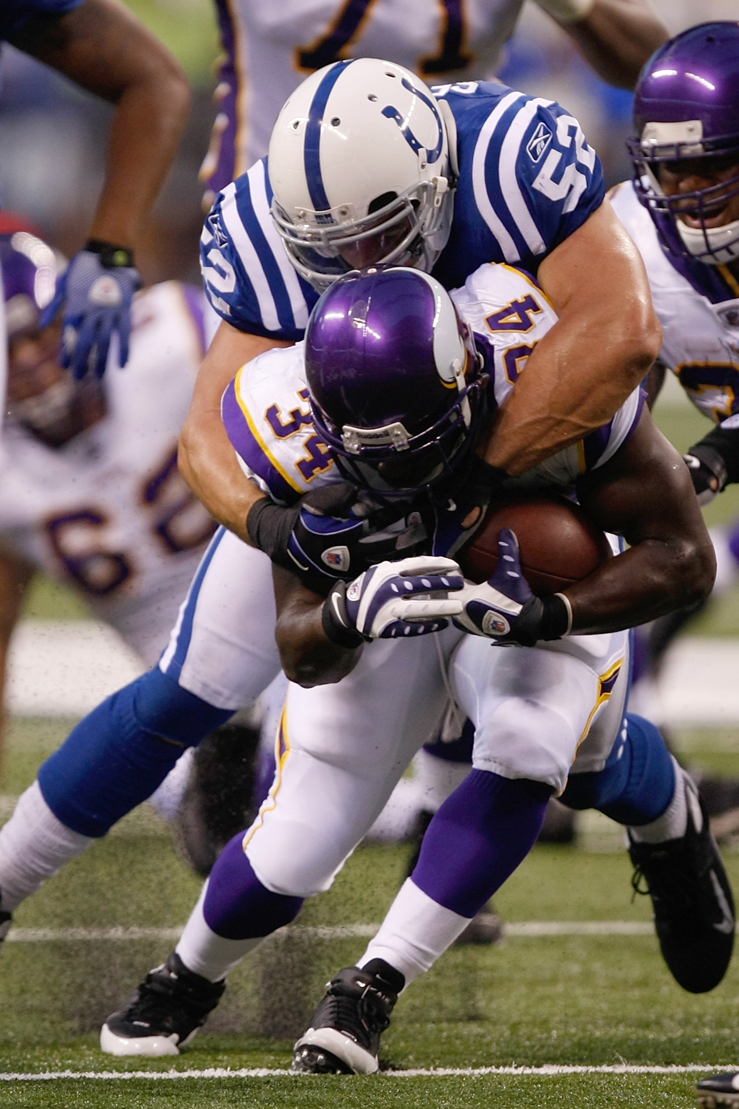 INDIANAPOLIS, IN - AUGUST 14: Running back Albert Young #34 of the Minnesota Vikings runs with the football as he is tackled by linebacker Adam Seward #52 of the Indianapolis Colts at Lucas Oil Stadium on August 14, 2009 in Indianapolis, Indiana. The Viki