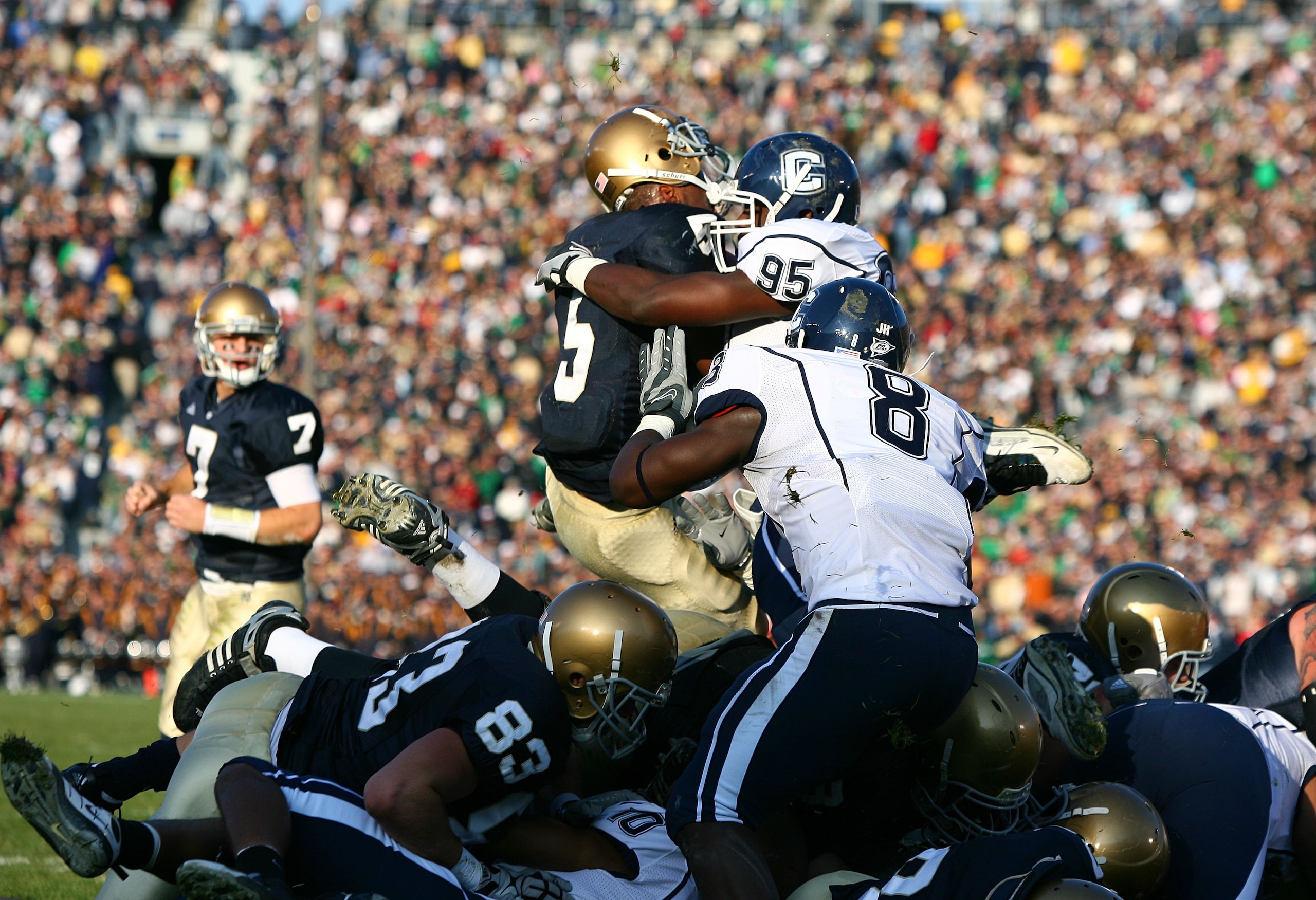 SOUTH BEND, IN - NOVEMBER 21: Armando Allen #5 of the Notre Dame Fighting Irish loses his helmet as he is hit at the goal line by Greg Lloyd #95 of the Univeristy of Connecticut Huskies at Notre Dame Stadium on November 21, 2009 in South Bend, Indiana. (P