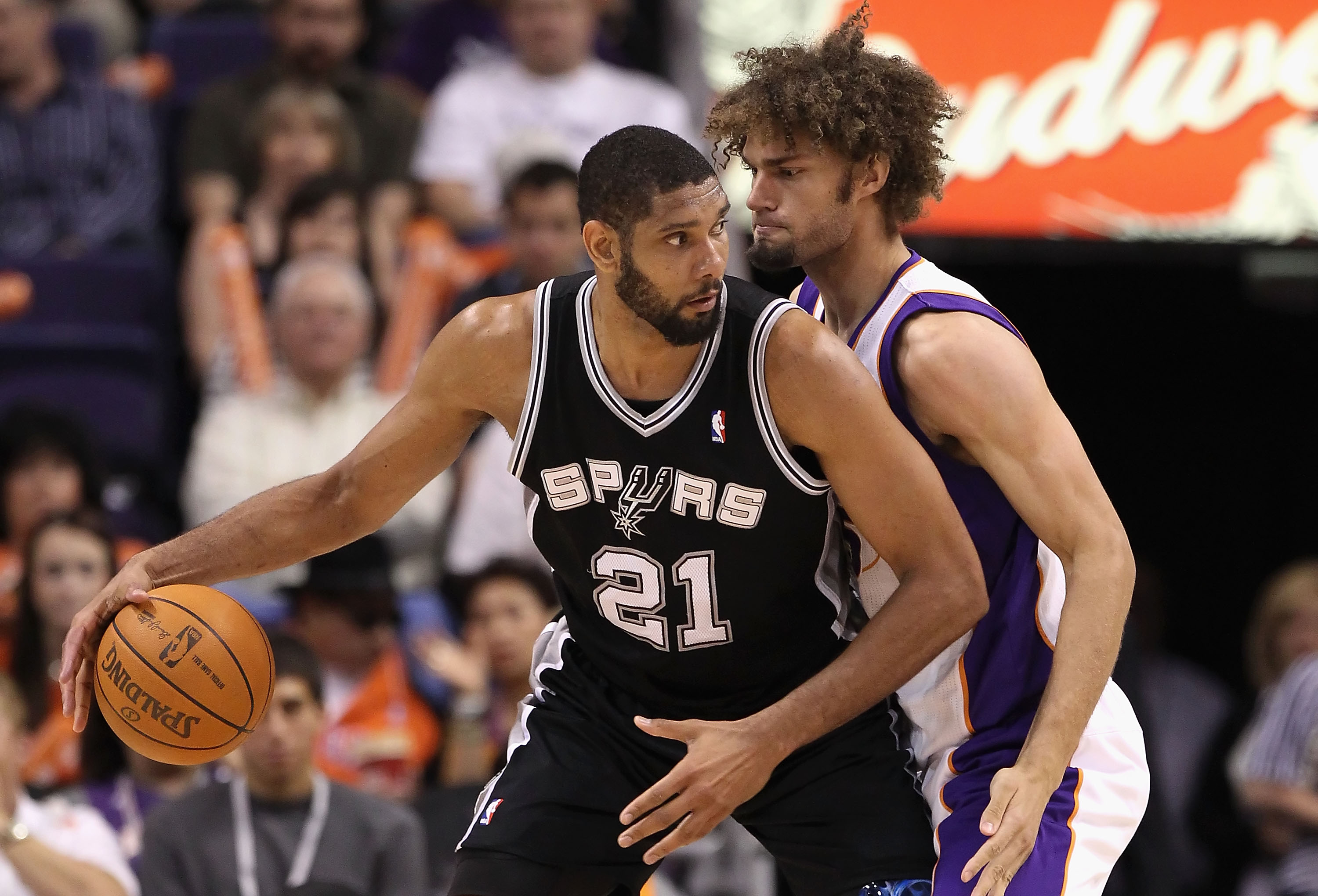 PHOENIX, AZ - APRIL 13:  Tim Duncan #21 of the San Antonio Spurs handles the ball under pressure from Robin Lopez #15 of the Phoenix Suns during the NBA game at US Airways Center on April 13, 2011 in Phoenix, Arizona.  NOTE TO USER: User expressly acknowl