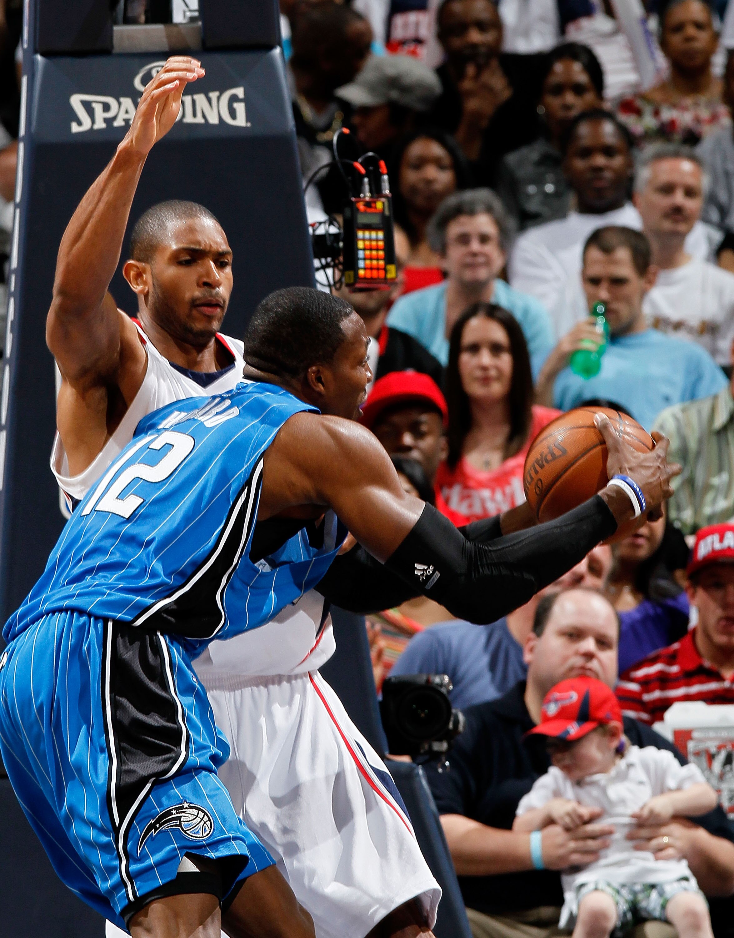 ATLANTA - MAY 08:  Dwight Howard #12 of the Orlando Magic draws a foul from Al Horford #15 of the Atlanta Hawks during Game Three of the Eastern Conference Semifinals during the 2010 NBA Playoffs at Philips Arena on May 8, 2010 in Atlanta, Georgia.  NOTE