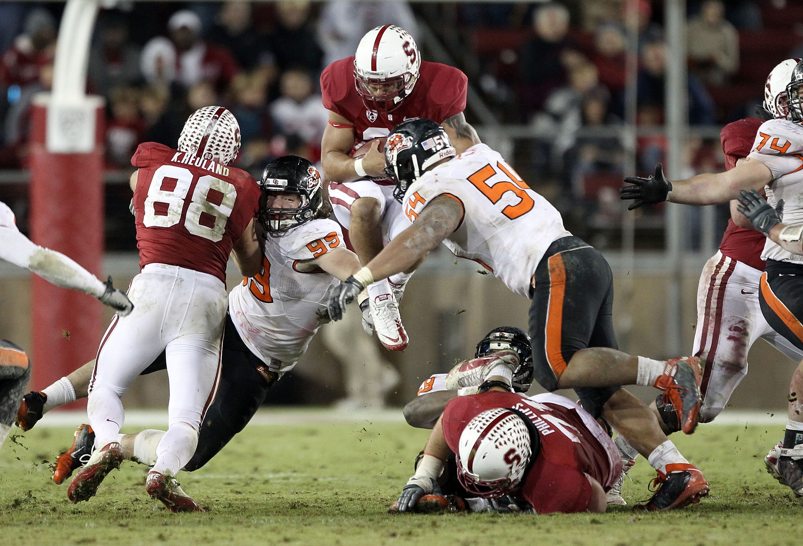PALO ALTO, CA - NOVEMBER 27:  Tyler Gaffney #25 of the Stanford Cardinal jumps in the air as he is hit by Stephen Paea #54 and Gabe Miller #99 of the Oregon State Beavers at Stanford Stadium on November 27, 2010 in Palo Alto, California.  (Photo by Ezra S