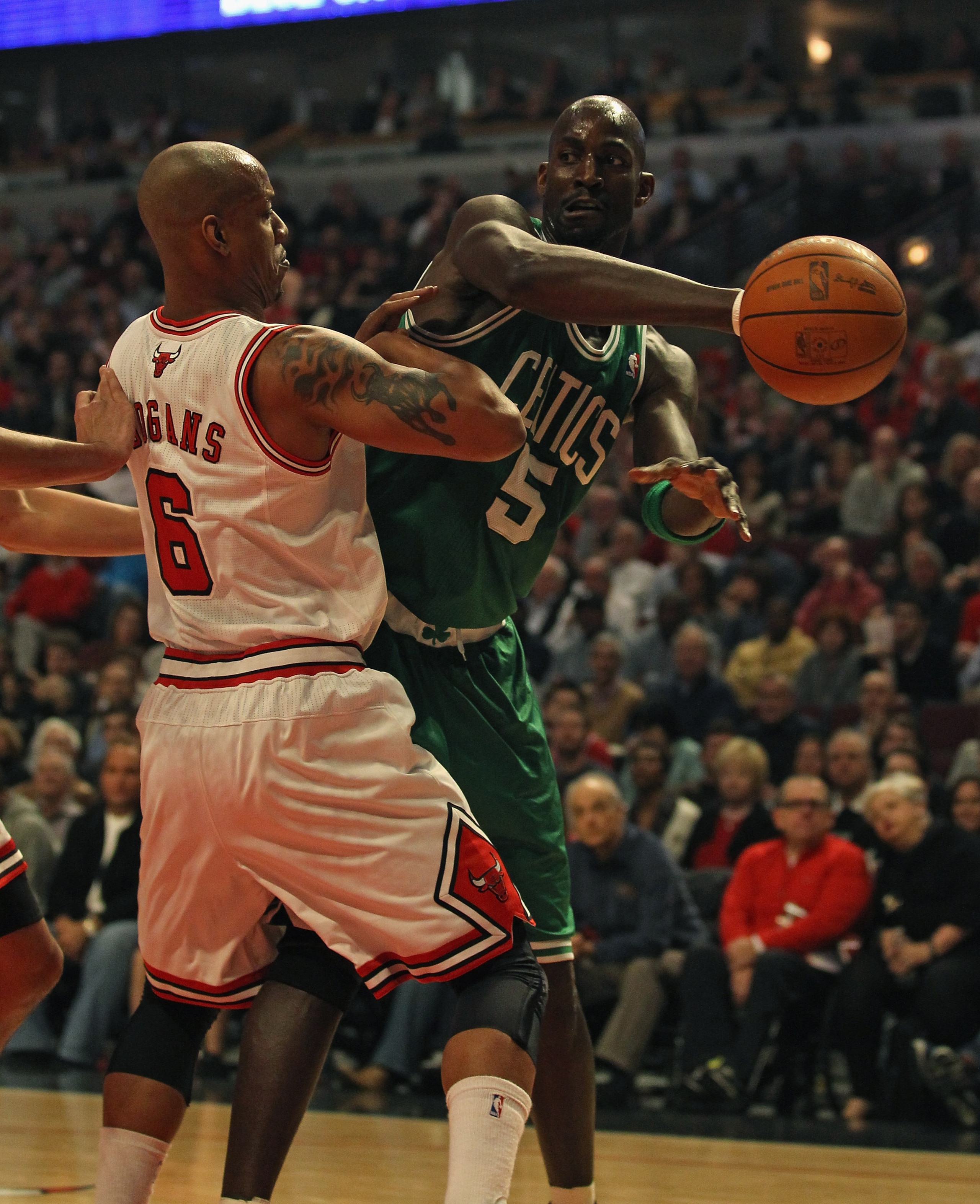 CHICAGO, IL - APRIL 07: Kevin Garnett #5 of the Boston Celtics passes the ball around Keith Bogans #6 of the Chicago Bulls at United Center on April 7, 2011 in Chicago, Illinois. NOTE TO USER: User expressly acknowledges and agress that, by downloading an