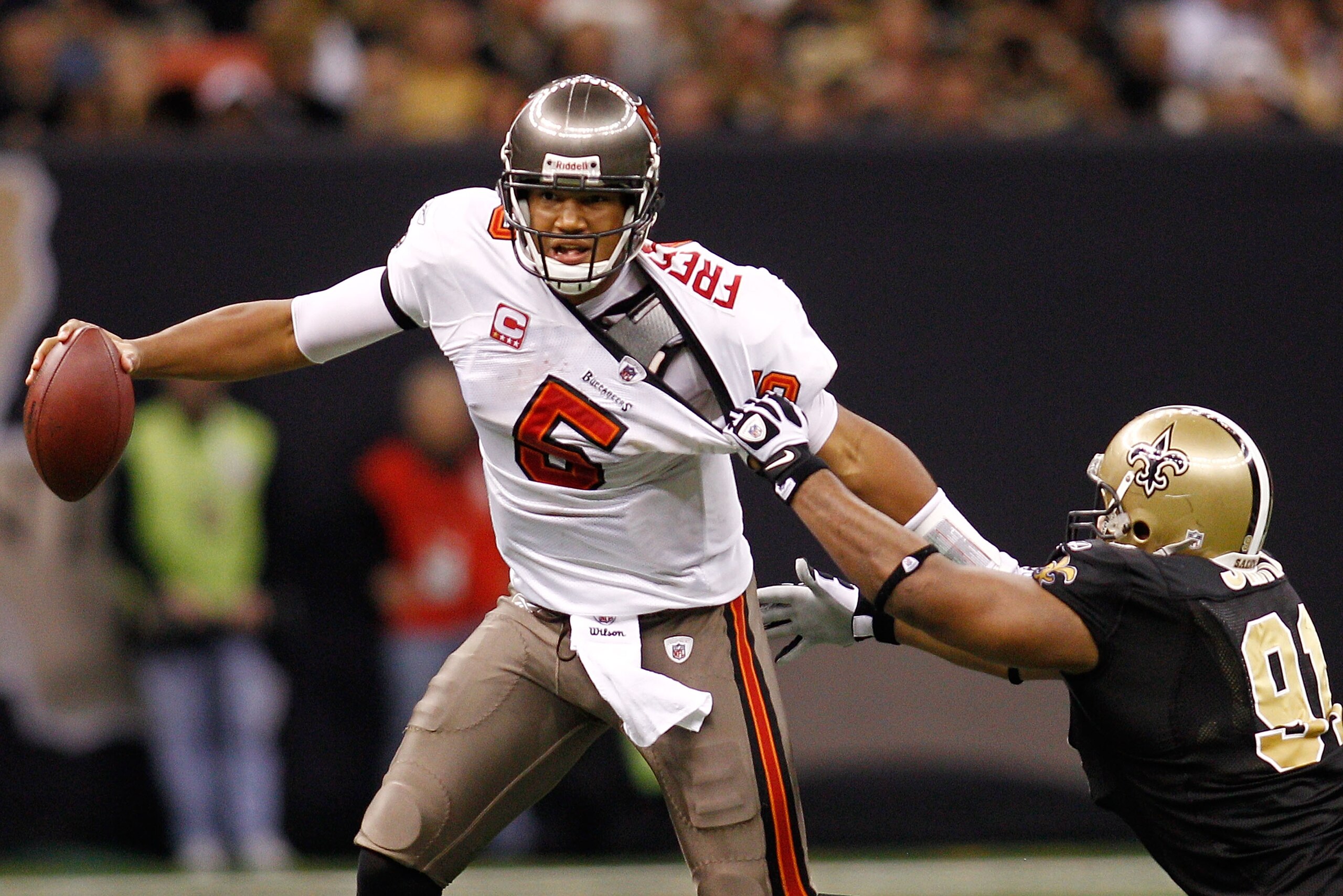 NEW ORLEANS, LA - JANUARY 02: Quarterback Josh Freeman #5 of the Tampa Bay Buccaneers avoids a tackle by Will Smith #91 of the New Orleans Saints at the Louisiana Superdome on January 2, 2011 in New Orleans, Louisiana. The Buccaneers defeated the Saint NEW ORLEANS, LA - JANUARY 02: Quarterback Josh Freeman #5 of the Tampa Bay Buccaneers avoids a tackle by Will Smith #91 of the New Orleans Saints at the Louisiana Superdome on January 2, 2011 in New Orleans, Louisiana. The Buccaneers defeated the Saint