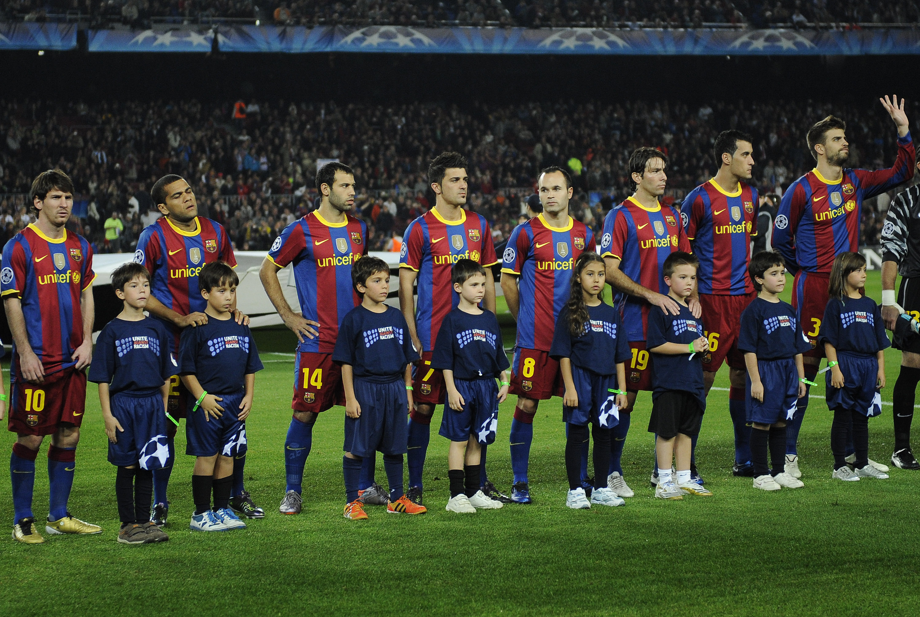 BARCELONA, SPAIN - OCTOBER 20:  Children wearing 'United against Racism T-shirts' pose with Barcelona players prior the start of the UEFA Champions League group D match between Barcelona and FC Copenhagen at the Camp nou stadium on October 20, 2010 in Bar