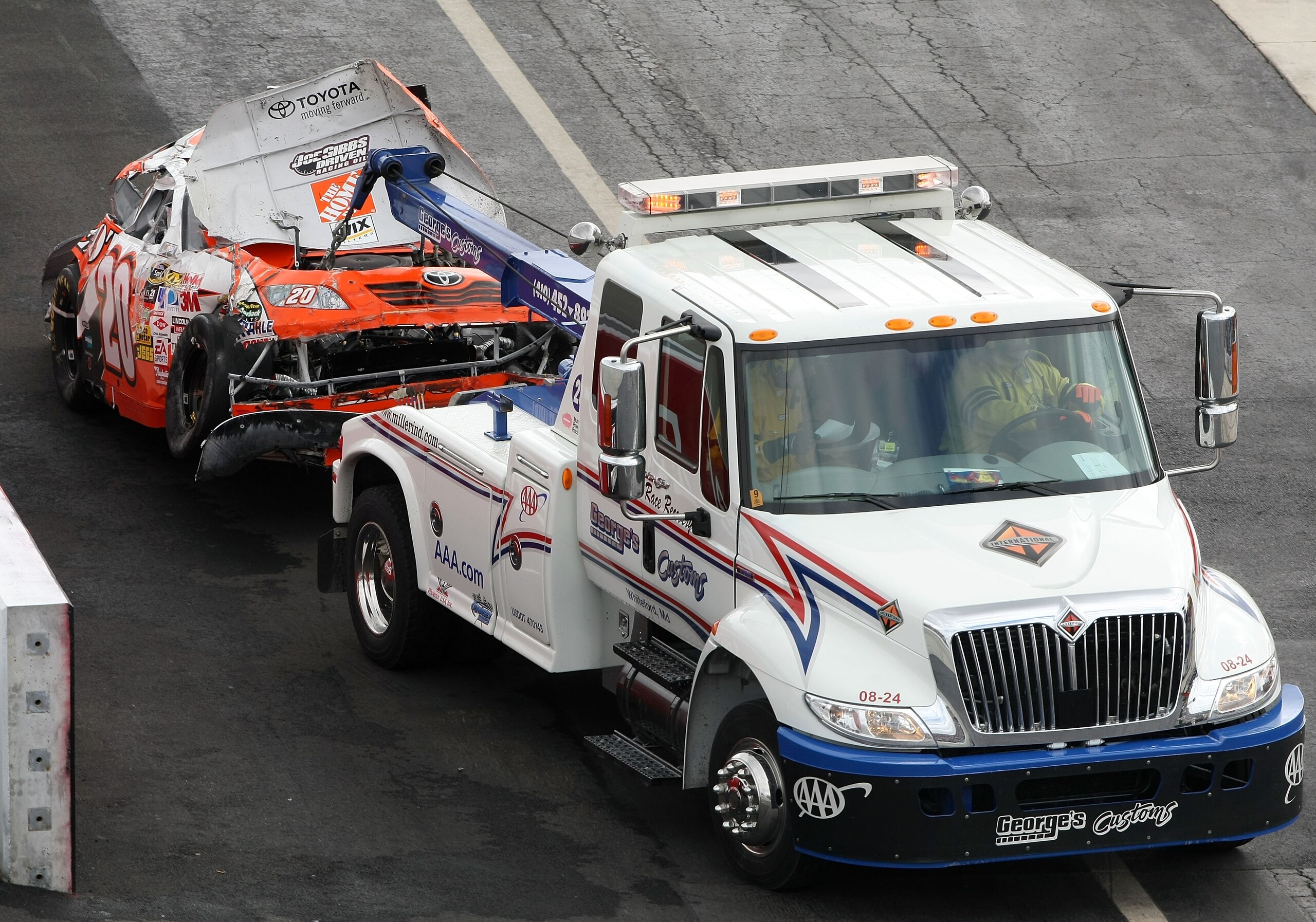 DOVER, DE - SEPTEMBER 27: A tow truck removes, Joey Logano's heavily damaged #20 Home Depot Chevrolet, off the track after it was involved in a wreck during the NASCAR Sprint Cup Series AAA 400 at Dover International Speedway on September 27, 2009 in Dov DOVER, DE - SEPTEMBER 27: A tow truck removes, Joey Logano's heavily damaged #20 Home Depot Chevrolet, off the track after it was involved in a wreck during the NASCAR Sprint Cup Series AAA 400 at Dover International Speedway on September 27, 2009 in Dov