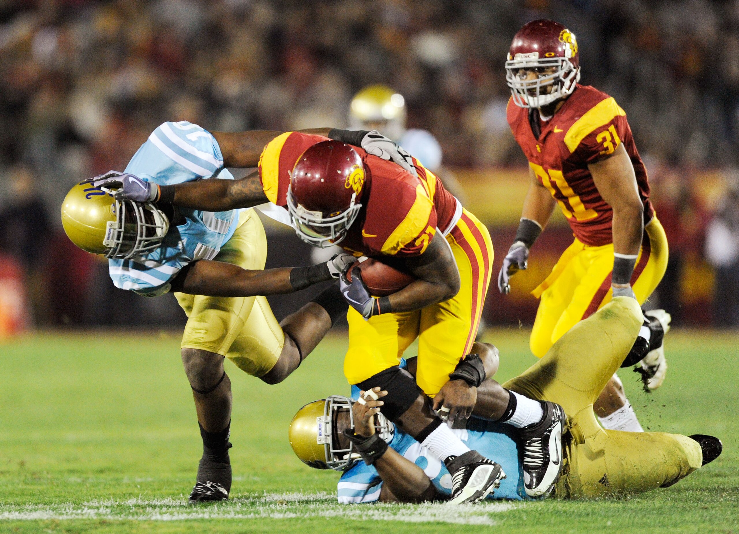 LOS ANGELES, CA - NOVEMBER 28: Allen Bradford #21 tailback of the USC Trojans breaks a tackle by Akeem Ayers #10 of the UCLA Bruins as he runs for a gain during the second quarter of the NCAA college football game at Los Angeles Memorial Coliseum on Nove LOS ANGELES, CA - NOVEMBER 28: Allen Bradford #21 tailback of the USC Trojans breaks a tackle by Akeem Ayers #10 of the UCLA Bruins as he runs for a gain during the second quarter of the NCAA college football game at Los Angeles Memorial Coliseum on Nove