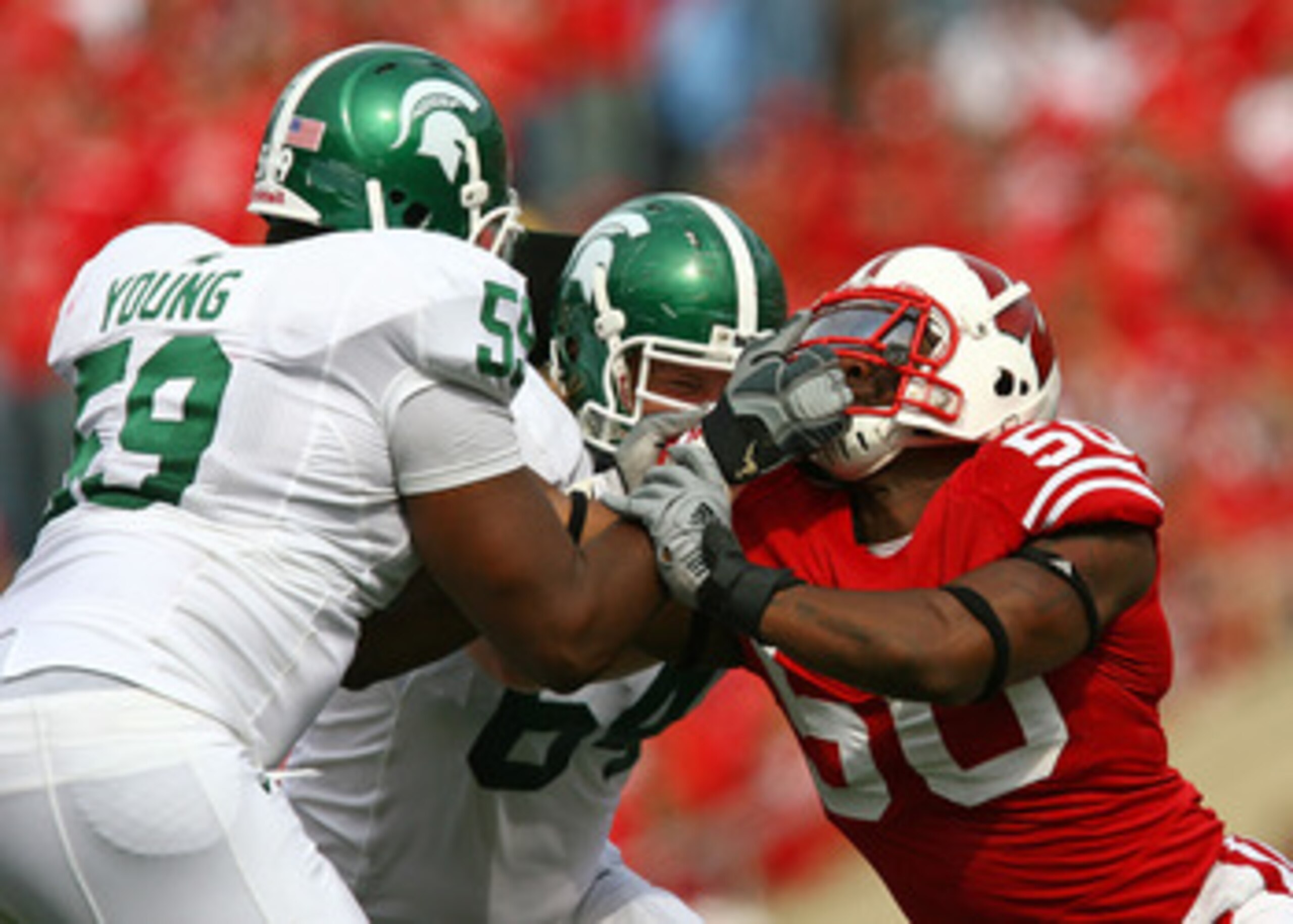 MADISON, WI - SEPTEMBER 26: D.J. Young #59 of the Michigan State Spartans tries to block O'Brien Schofiled #50 of the Wisconsin Badgers by grabbing his face mask on September 26, 2009 at Camp Randall Stadium in Madison, Wisconsin. Wisconsin defeated Michi