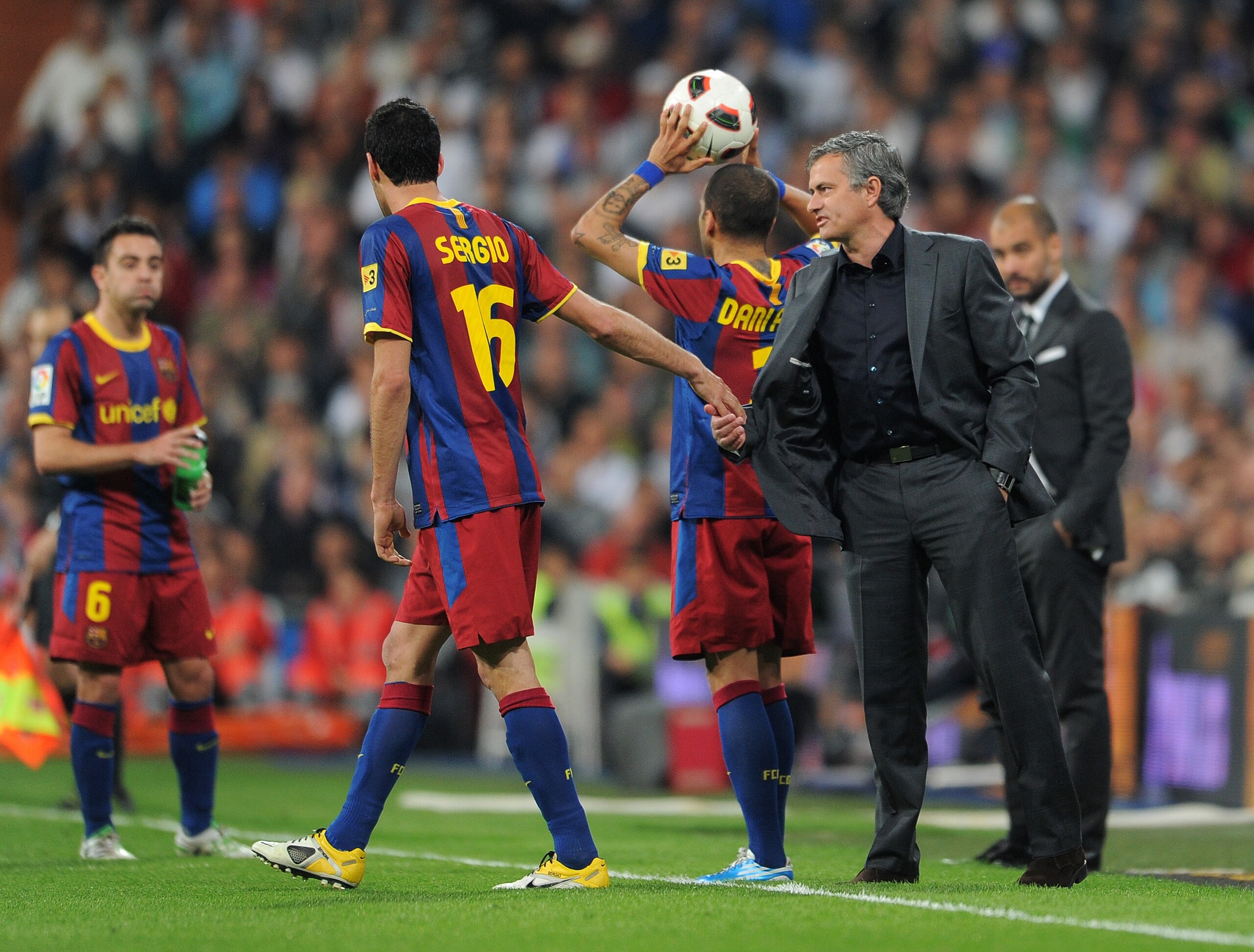 MADRID, SPAIN - APRIL 16: Sergio Busquets (L) of Barcelona holds head coach Jose Mourinho (R) of Real Madrid by his shirt as they chat while head coach Josep Guardiola of Barcelona looks on in the background during the la Liga match between Real Madrid a MADRID, SPAIN - APRIL 16: Sergio Busquets (L) of Barcelona holds head coach Jose Mourinho (R) of Real Madrid by his shirt as they chat while head coach Josep Guardiola of Barcelona looks on in the background during the la Liga match between Real Madrid a